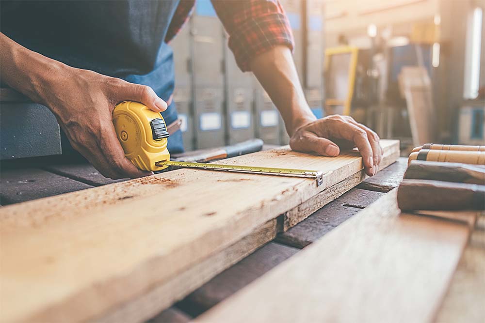 Carpenter Building Shelving In A Workshop