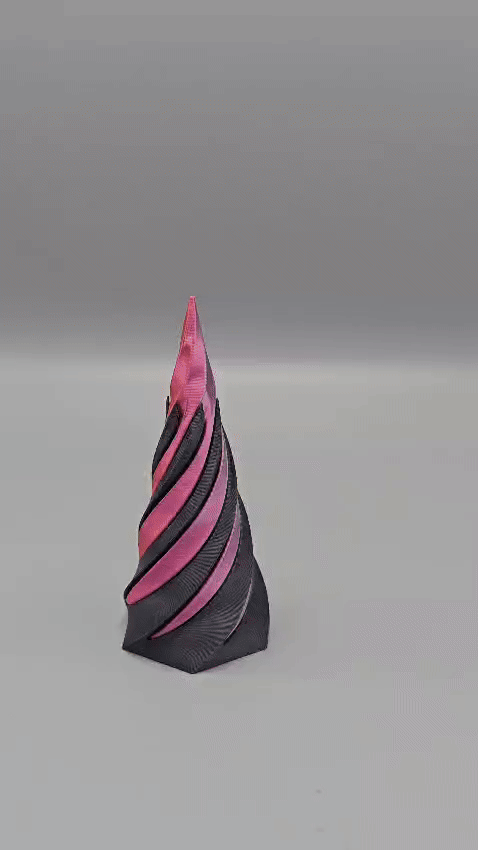 Wervelend, kegelvormig beeld, donkergrijs met roze spiralen, tegen een lichtgrijze achtergrond.