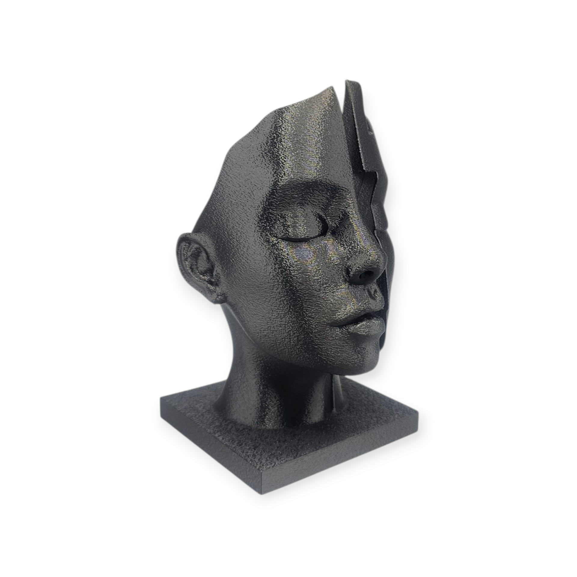 Een getextureerde, donkergrijze sculptuur van een menselijk gezicht, verticaal in twee delen gesplitst, geplaatst tegen een neutrale achtergrond.