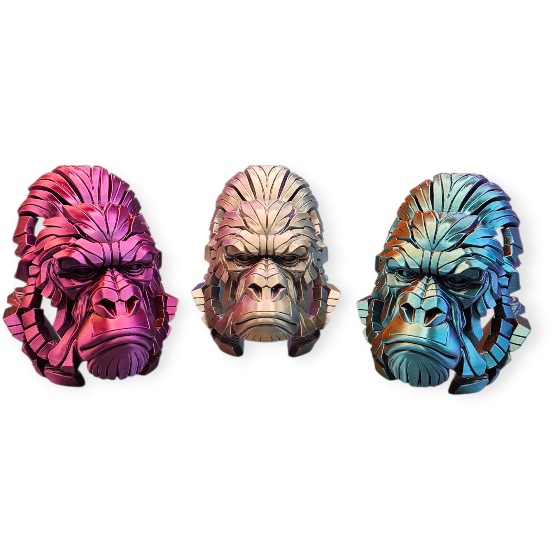 Drie metalen gorillakoppen in roze, brons en blauw, met ingewikkelde geometrische details en een neutrale uitdrukking.