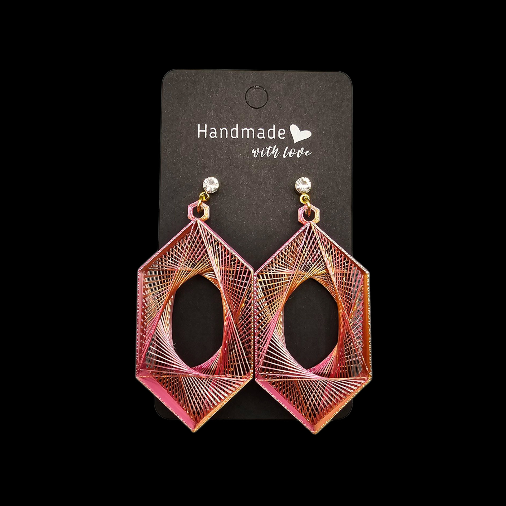 Een paar geometrische, roze en goudkleurige, zeshoekige oorbellen met hangertjes, op een zwart kaartje met de tekst