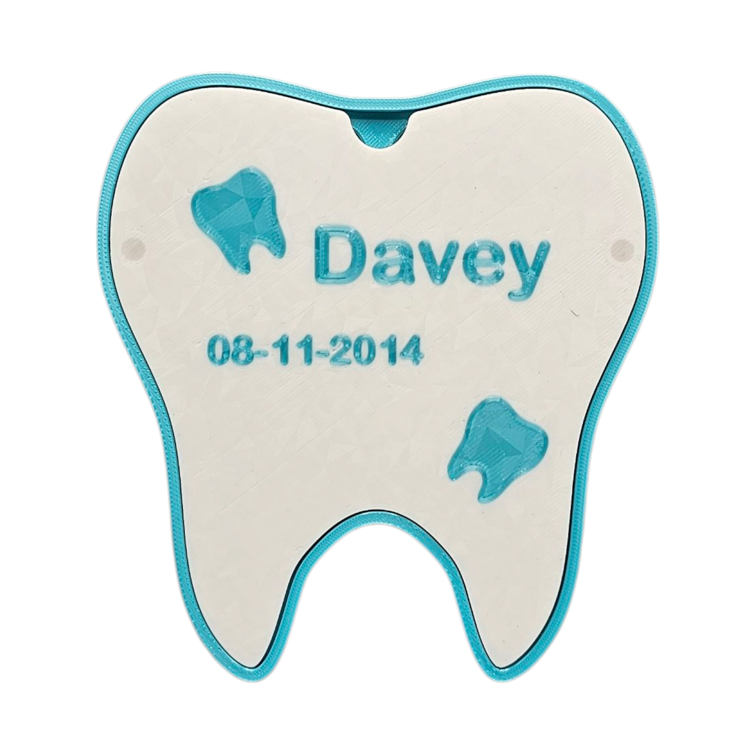 Een tandvormig doosje in lichtblauw en wit, met de naam "Davey" en de datum "08-11-2014" erop gegraveerd.