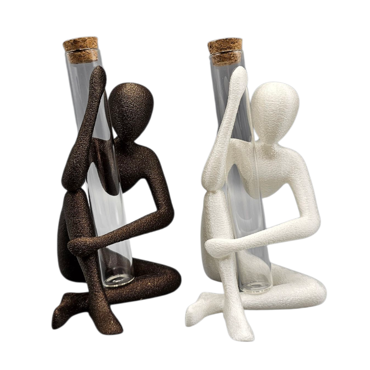 Twee abstracte, gestructureerde figuren – een zwart, een wit – zitten elk en houden een doorzichtige glazen reageerbuis met kurkstop vast.