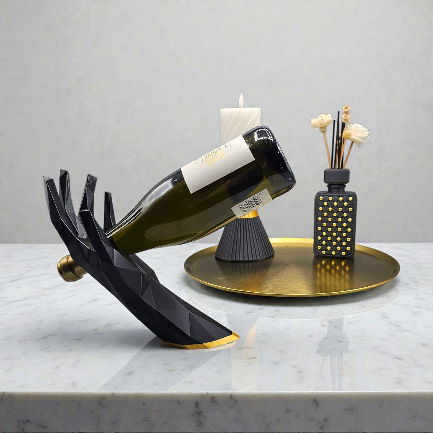 Een modern, zwart, geometrisch handbeeld op een houten tafel houdt een wijnfles vast, naast een gouden kandelaar.
