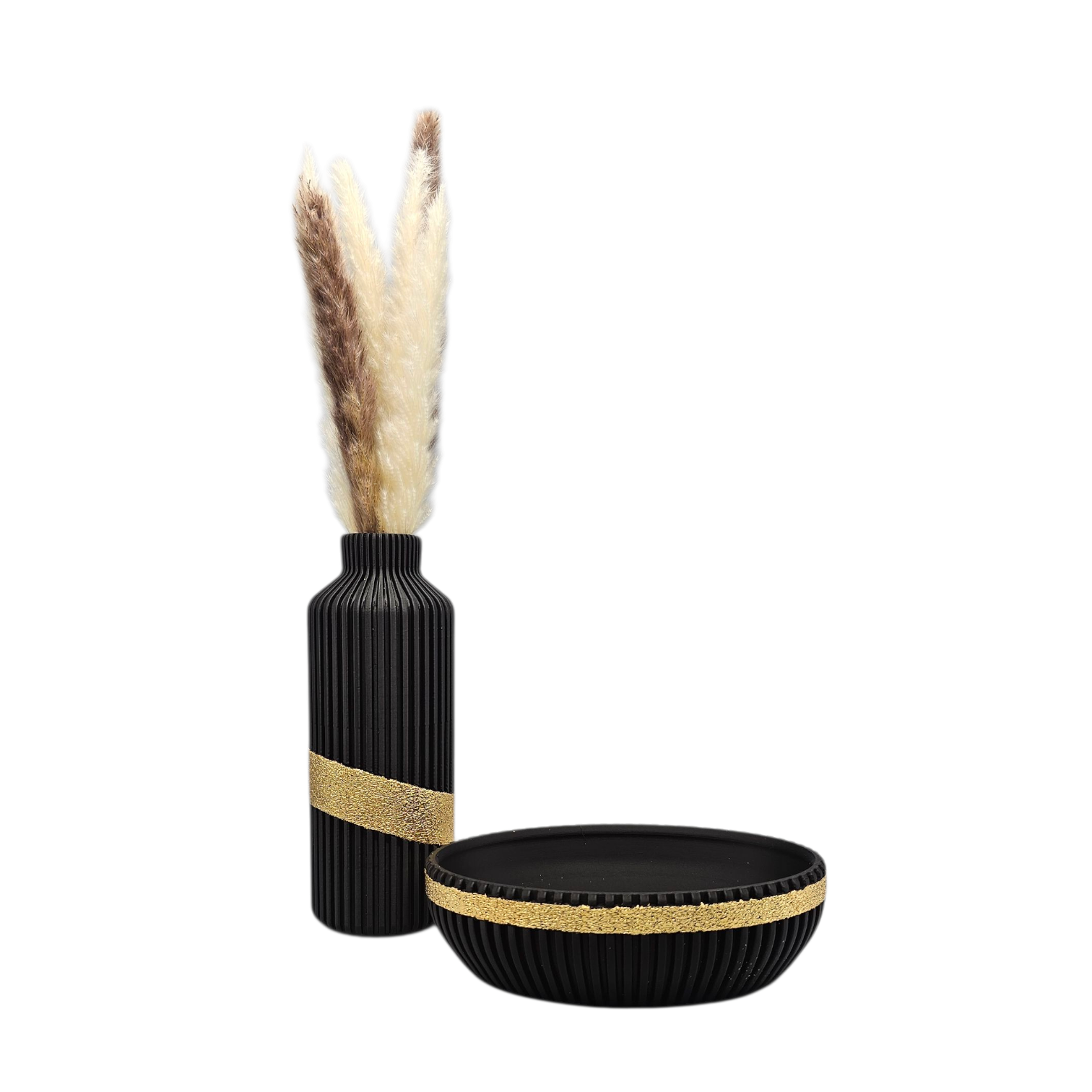 Een zwarte vaas met pampasgras, twee theelichtjes en een schaal op een zwart dienblad tegen een beige en gouden muur.