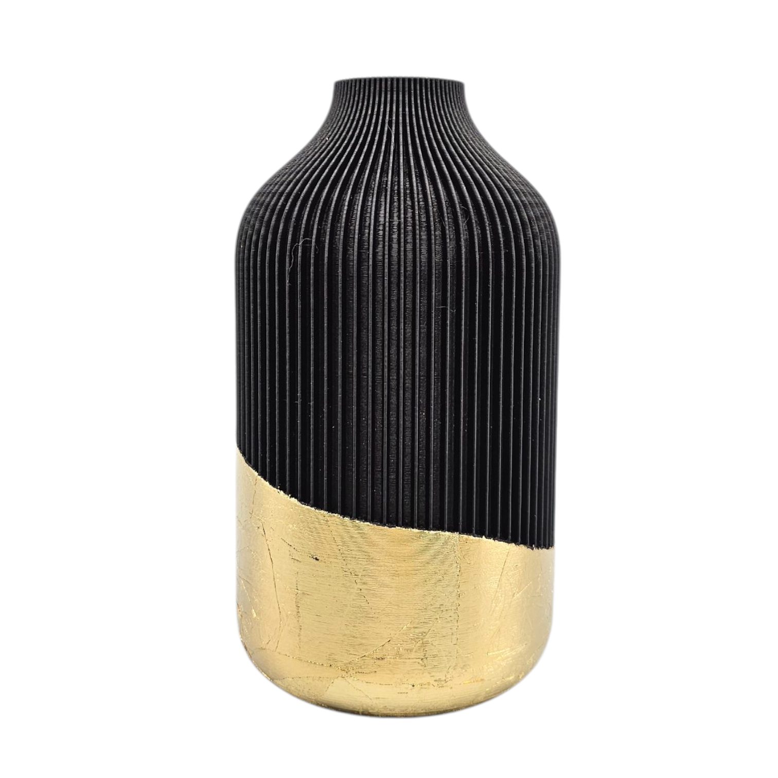 Een kleine kaars en een hoge vaas met pampasgras, beide zwart met gouden voetstukken, staan op een ronde marmeren tafel naast een lamp.