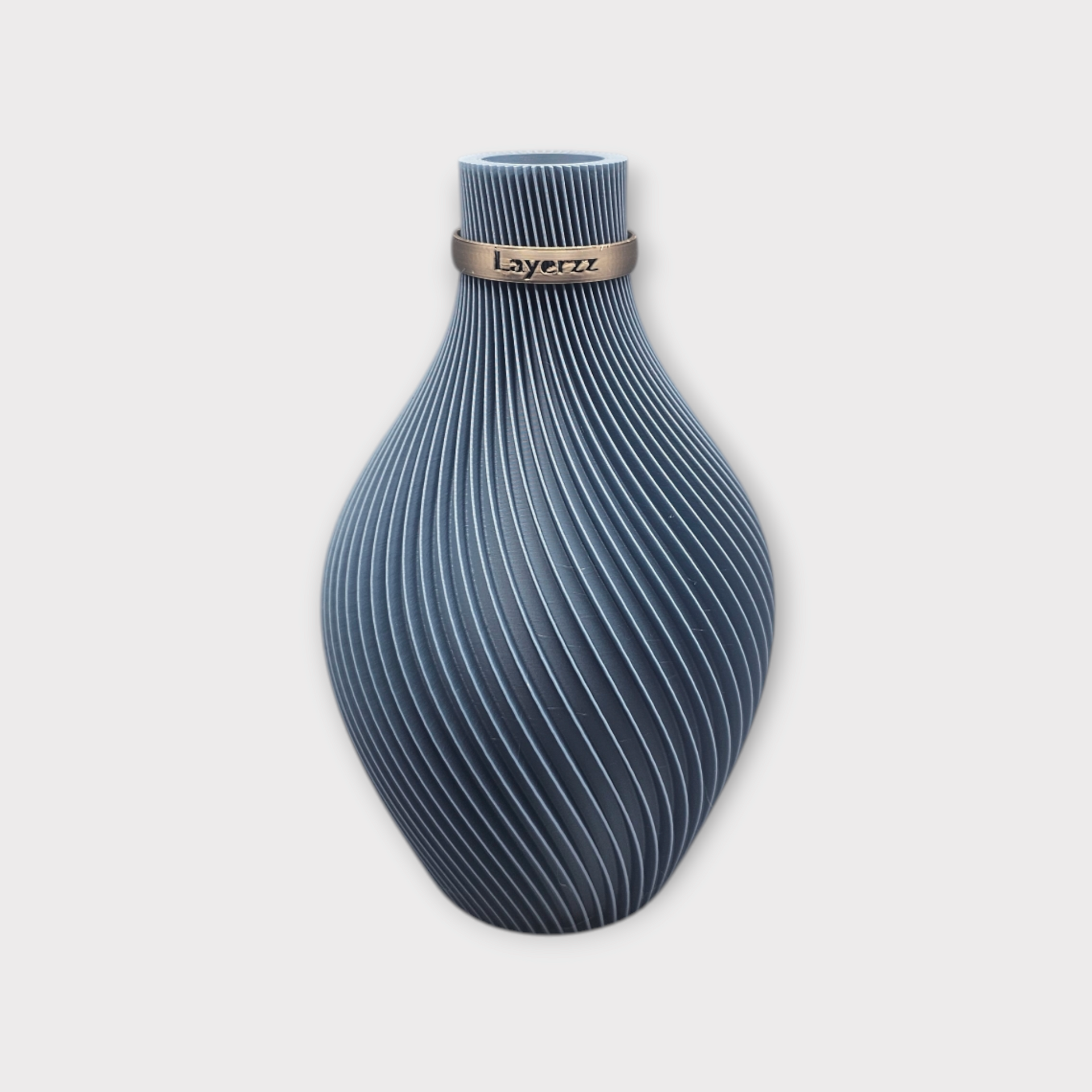 Een blauwe, peervormige vaas met delicate, witte, wervelende verticale lijnen en een smalle, goudkleurige band rond de hals.