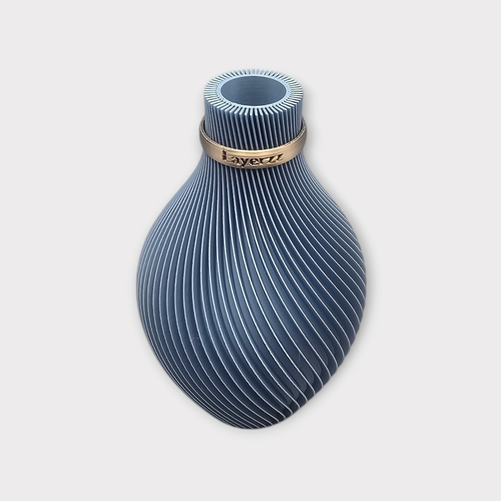 Een blauwe, peervormige vaas met delicate, witte, wervelende verticale lijnen en een smalle, goudkleurige band rond de hals.