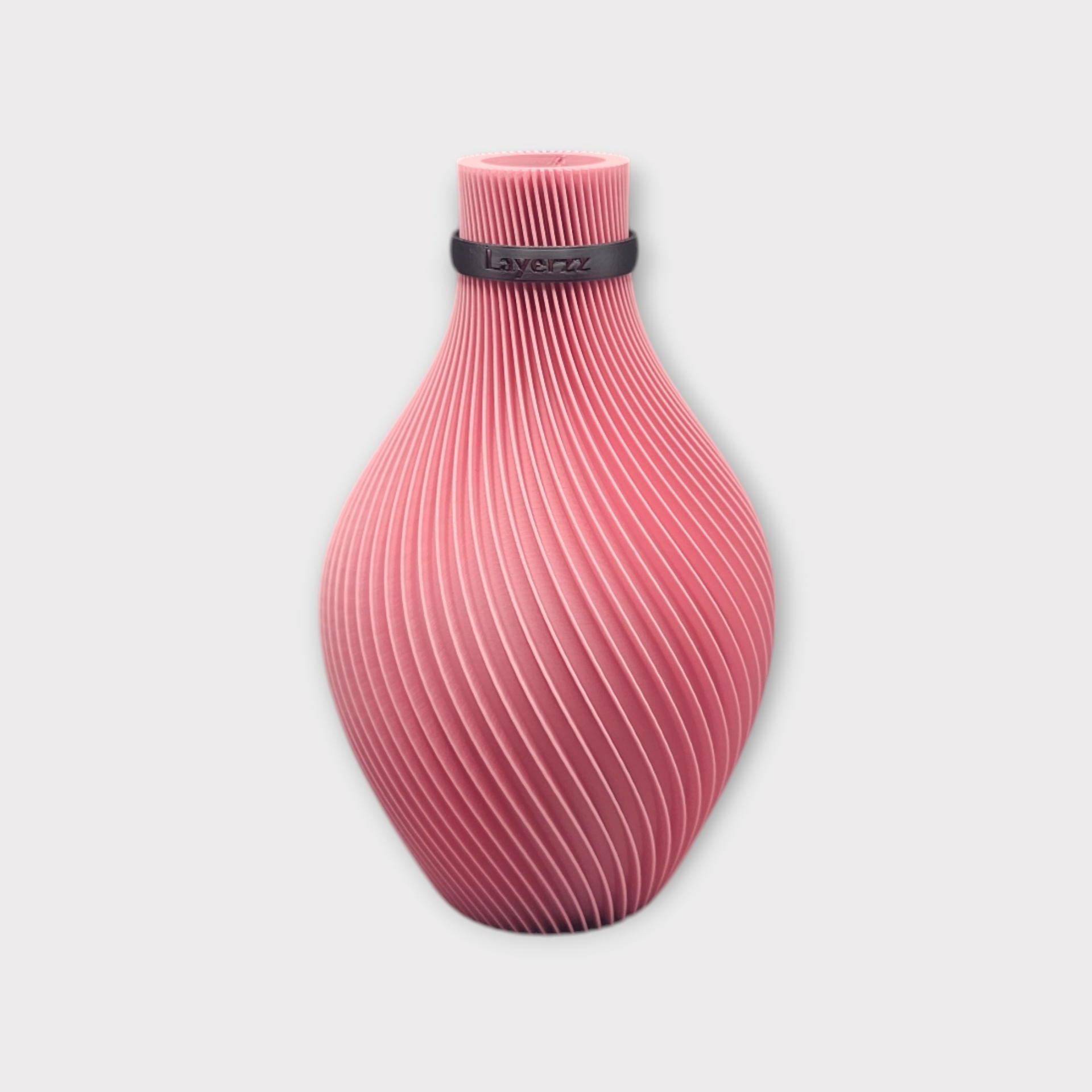 Een roze, 3D-geprinte vaas met een gestructureerd, spiraalvormig ribbelpatroon en een zwarte ring rond de hals.