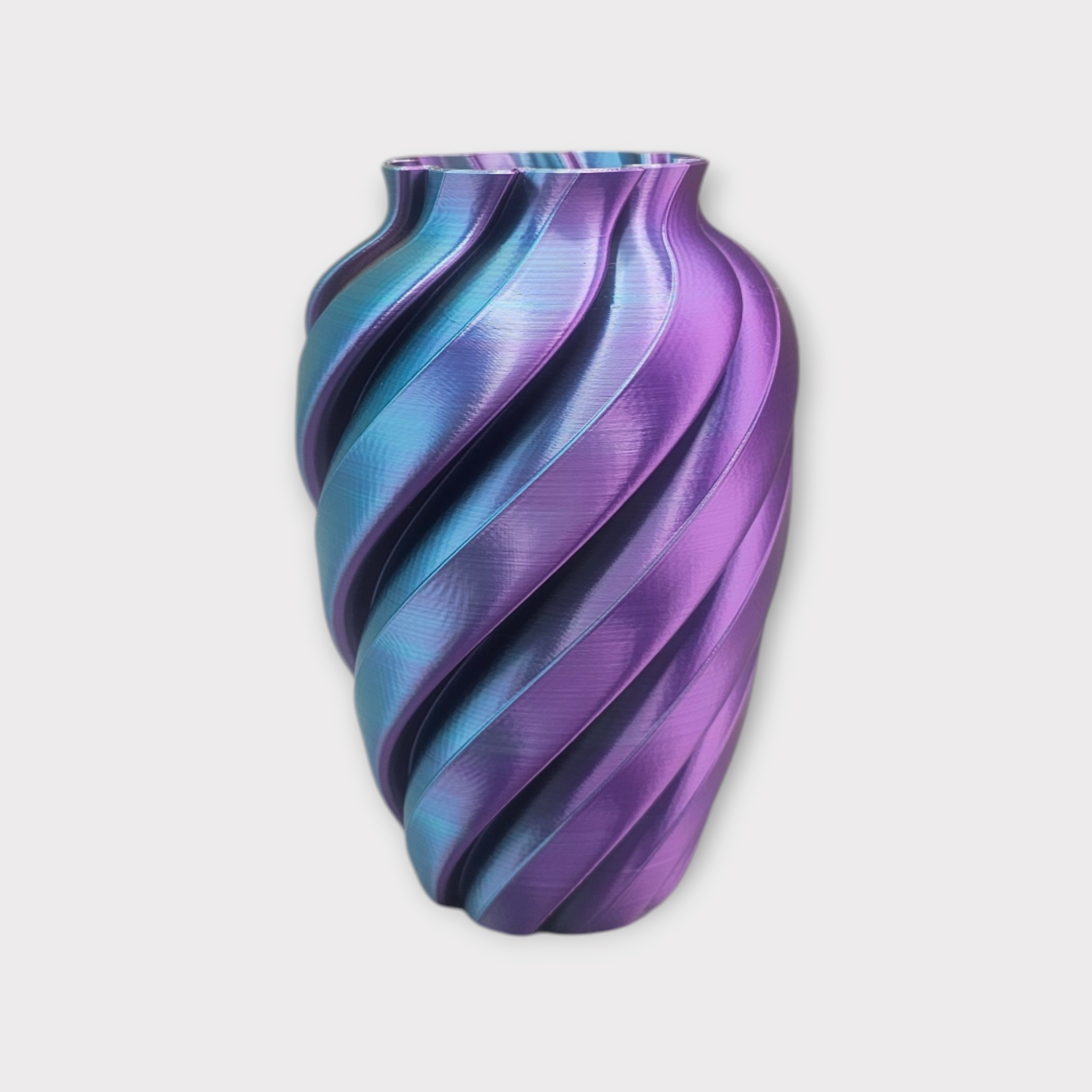 Een decoratieve vaas met een spiraalvormige, geribbelde textuur, met een iriserend kleurverloop van metallic paarse en blauwe tinten.