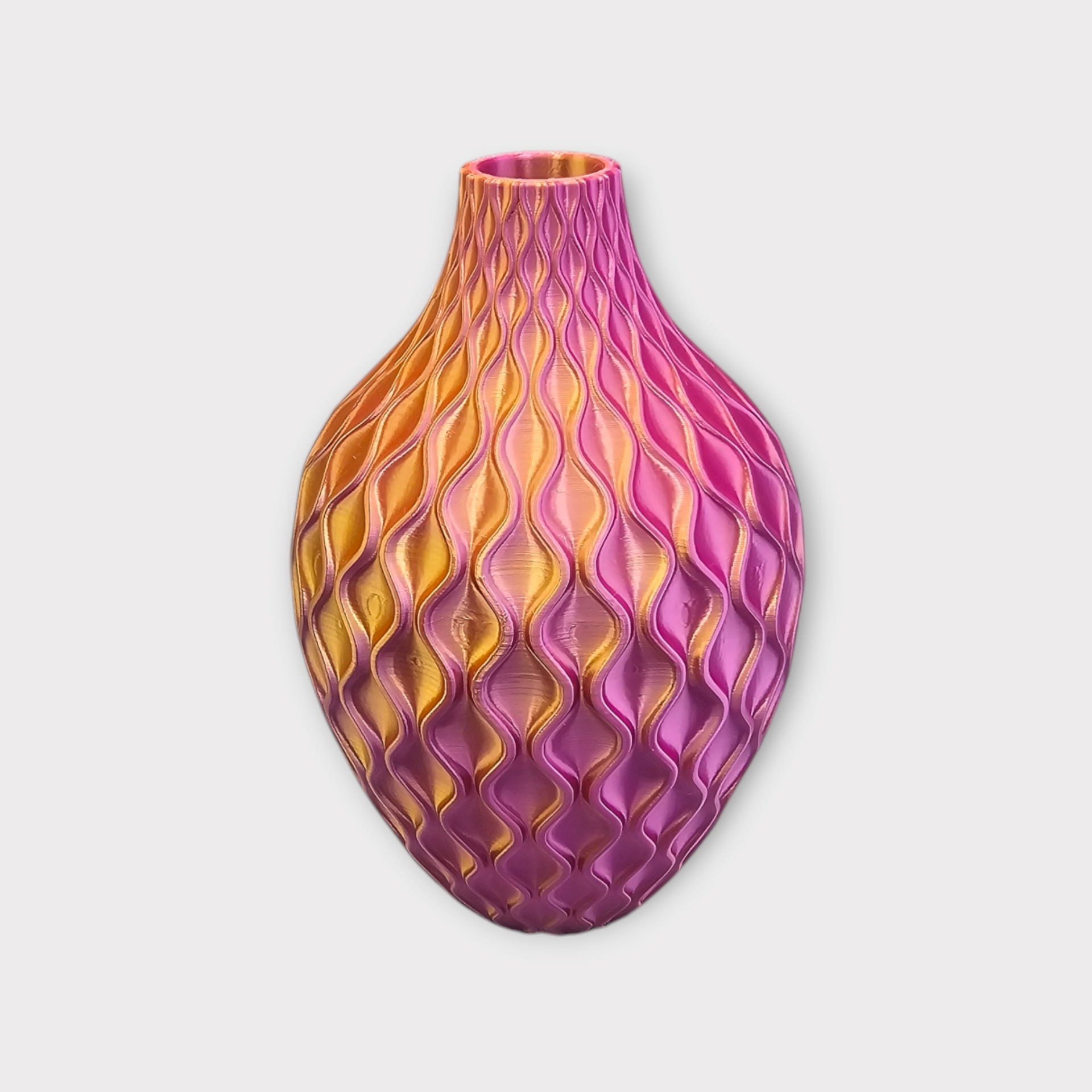 Een vaas met een structuur en parelmoerglans, met een ombré-kleurverloop dat overgaat van goudgeel naar magenta-paars.