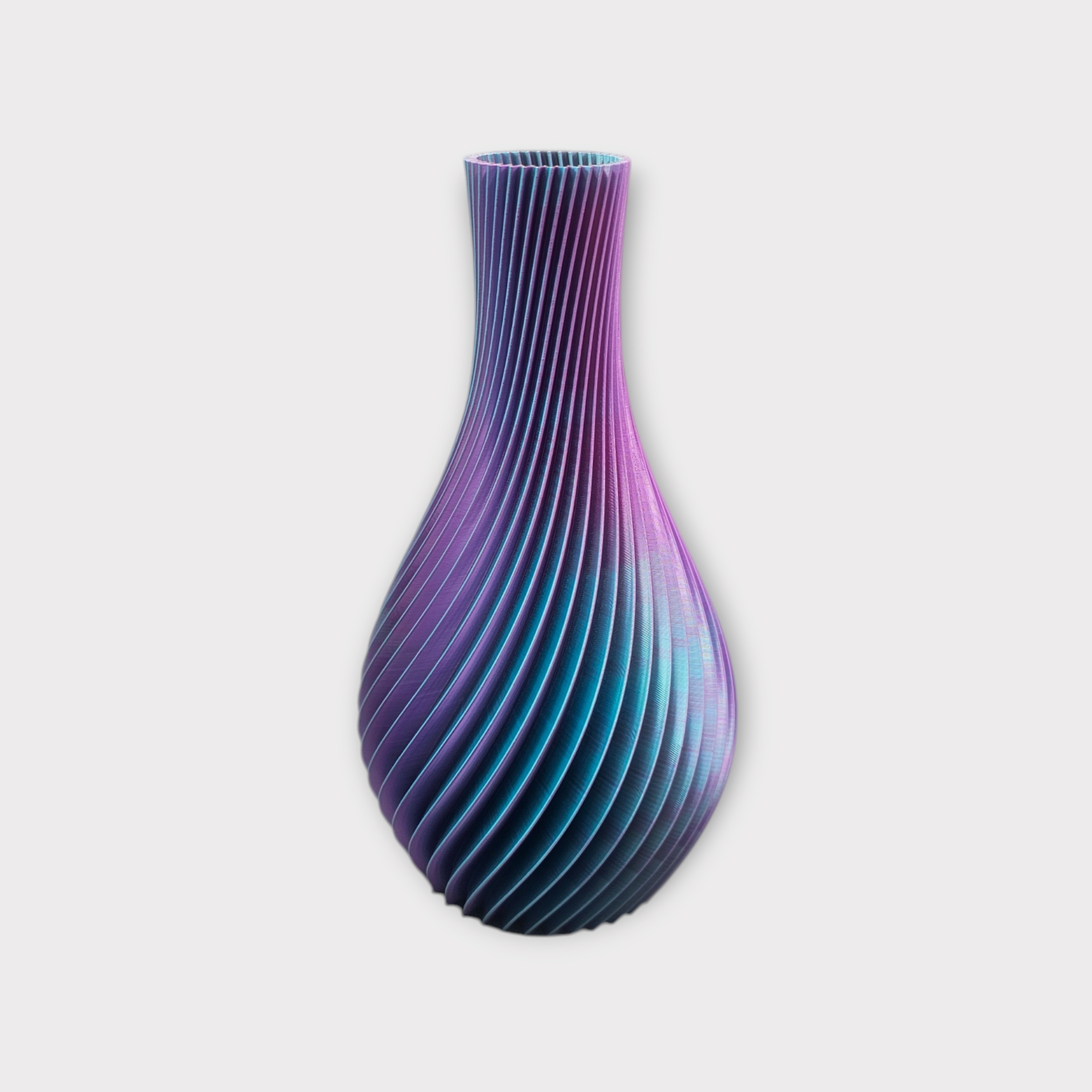 Een 3D-geprinte vaas met een spiraalvormige, geribbelde textuur, waarbij de kleur verloopt van dieppaars aan de bovenkant naar blauw aan de onderkant.