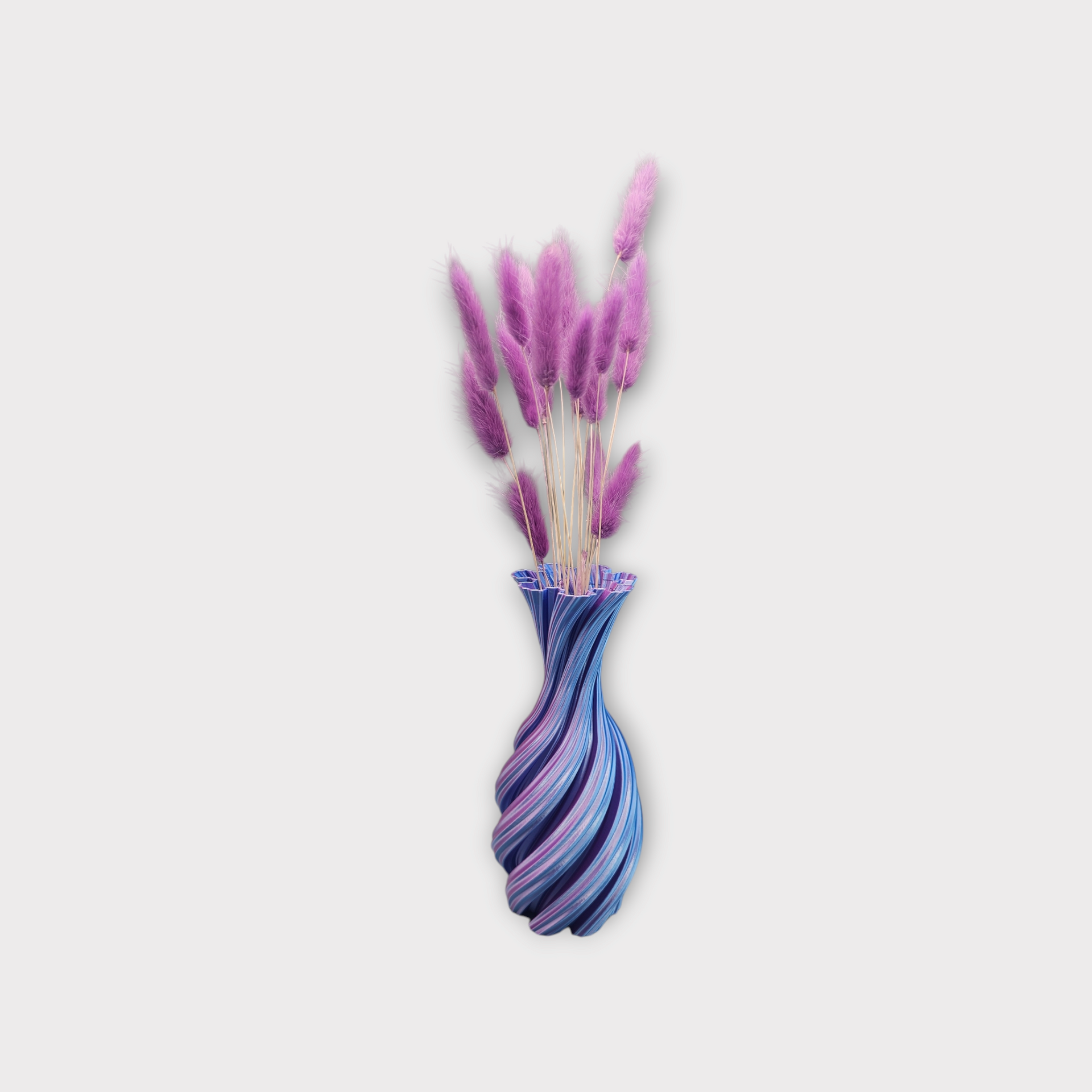 Een 3D-geprinte, spiraalvormige vaas met een gegroefde hals, voorzien van afwisselende verticale strepen in magenta en goud.
