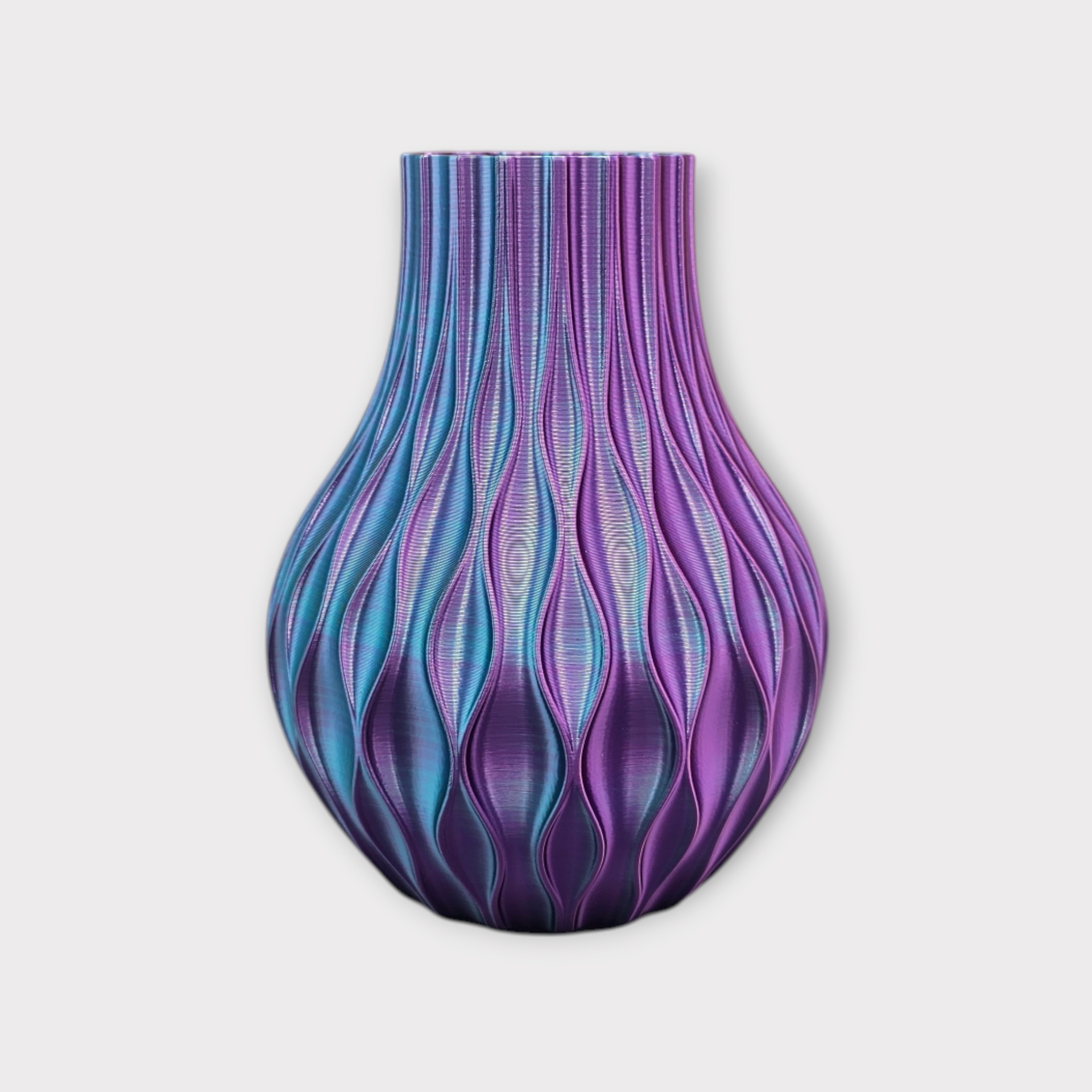 Een bolvormige, 3D-geprinte vaas met een herhalende verticale golfstructuur, in een kleurverloop van metallic blauw en paars.