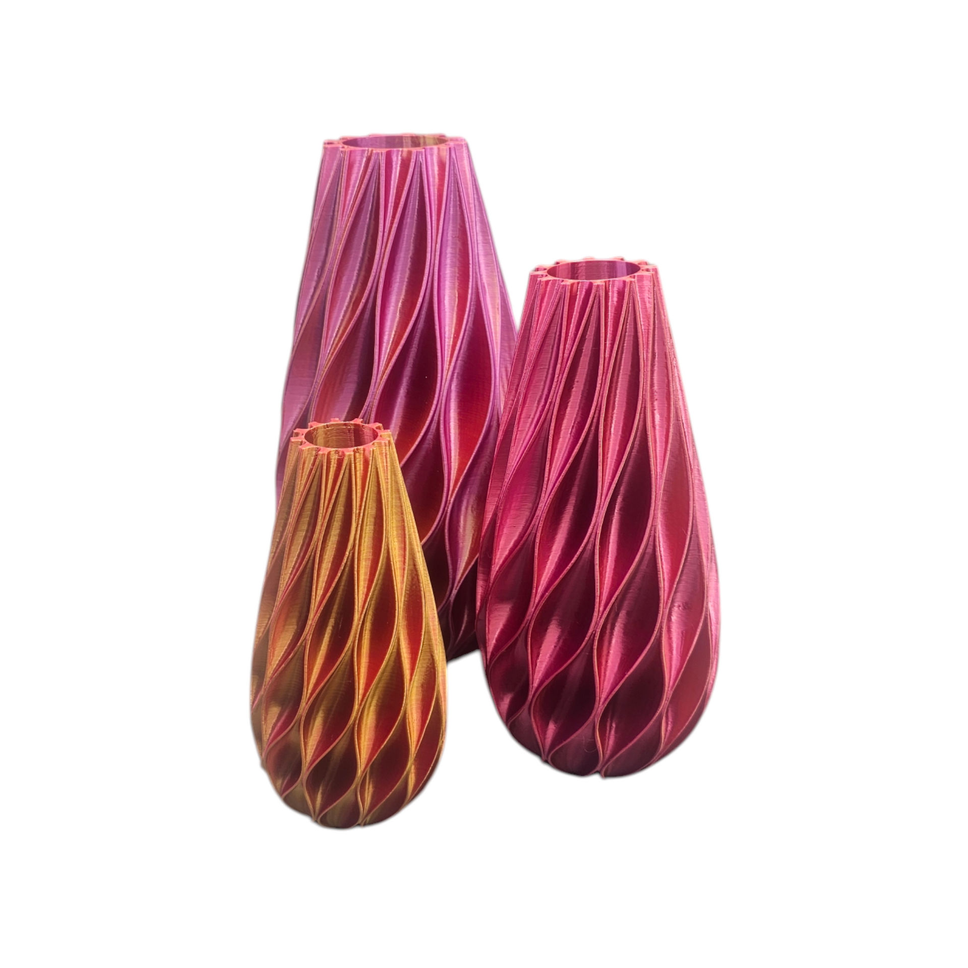 Drie 3D-geprinte vazen met een gestructureerd, verticaal ribbelpatroon, met kleurverlopen in roze, rood en oranje.