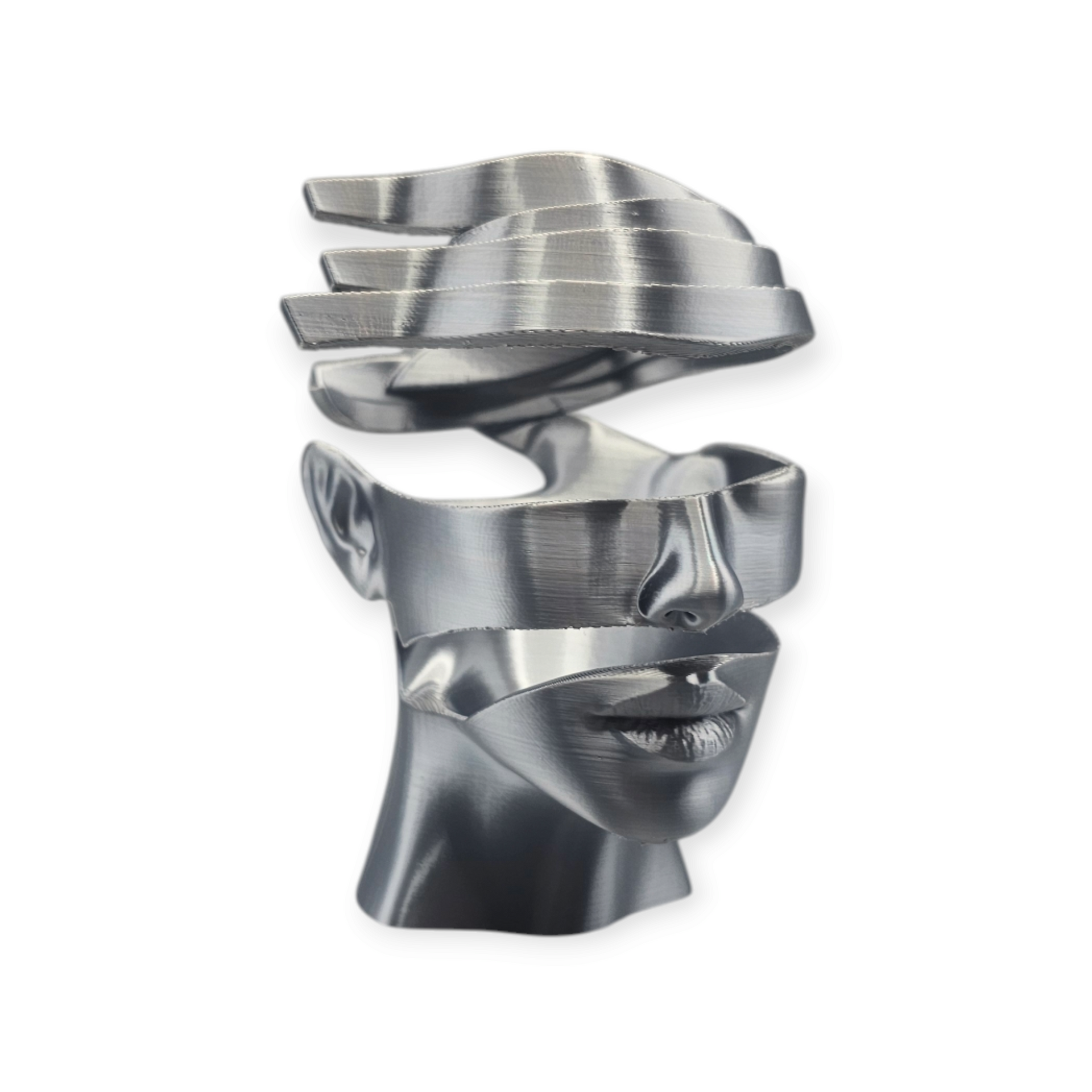 Een bronskleurige sculptuur van een menselijk gezicht, opgedeeld in zwevende horizontale lagen, tentoongesteld op een marmeren ondergrond.