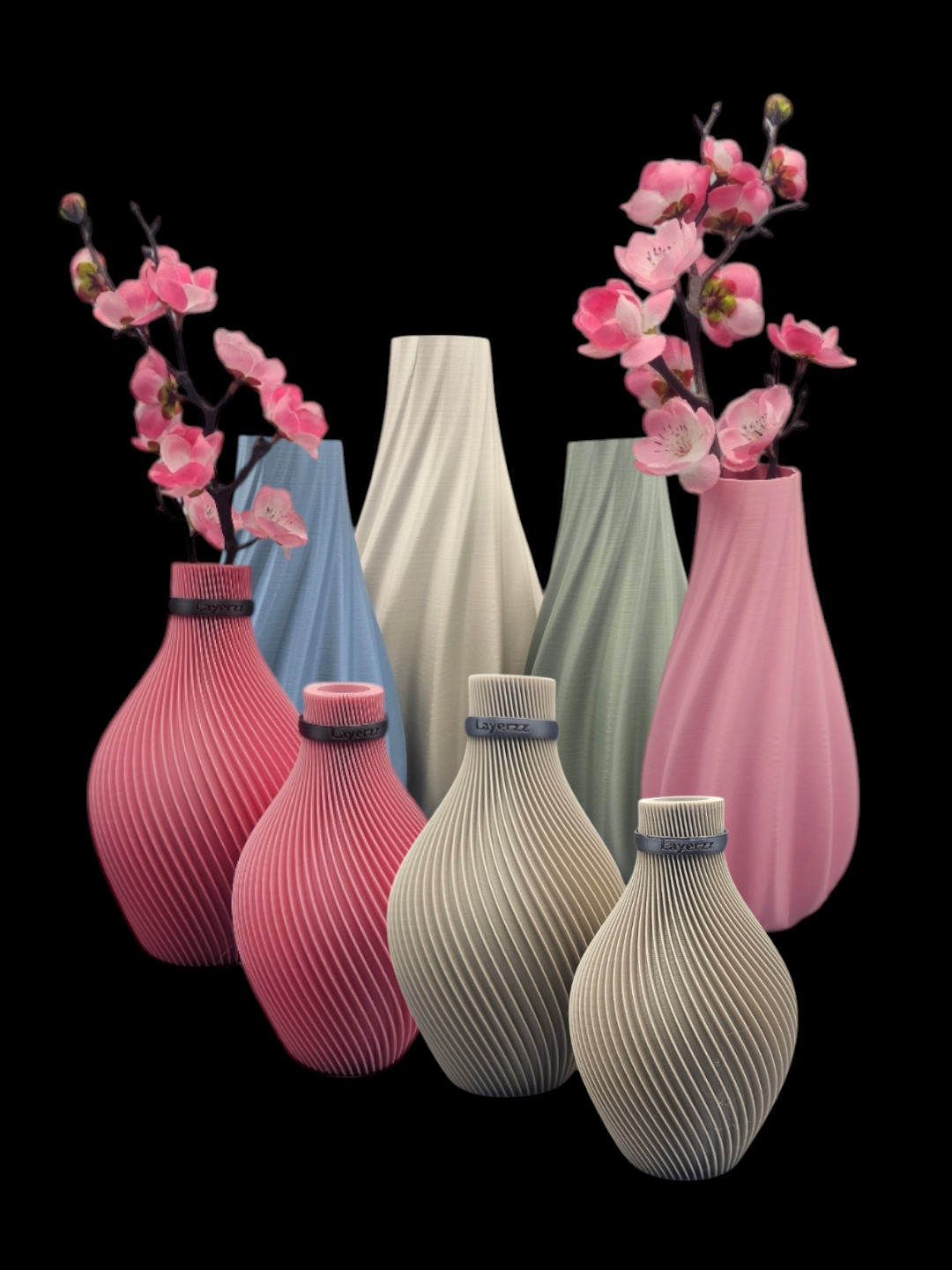 Een collectie van acht diverse decoratieve vazen ​​in pastelkleuren en met verschillende texturen, elk met twee stelen roze bloemen.