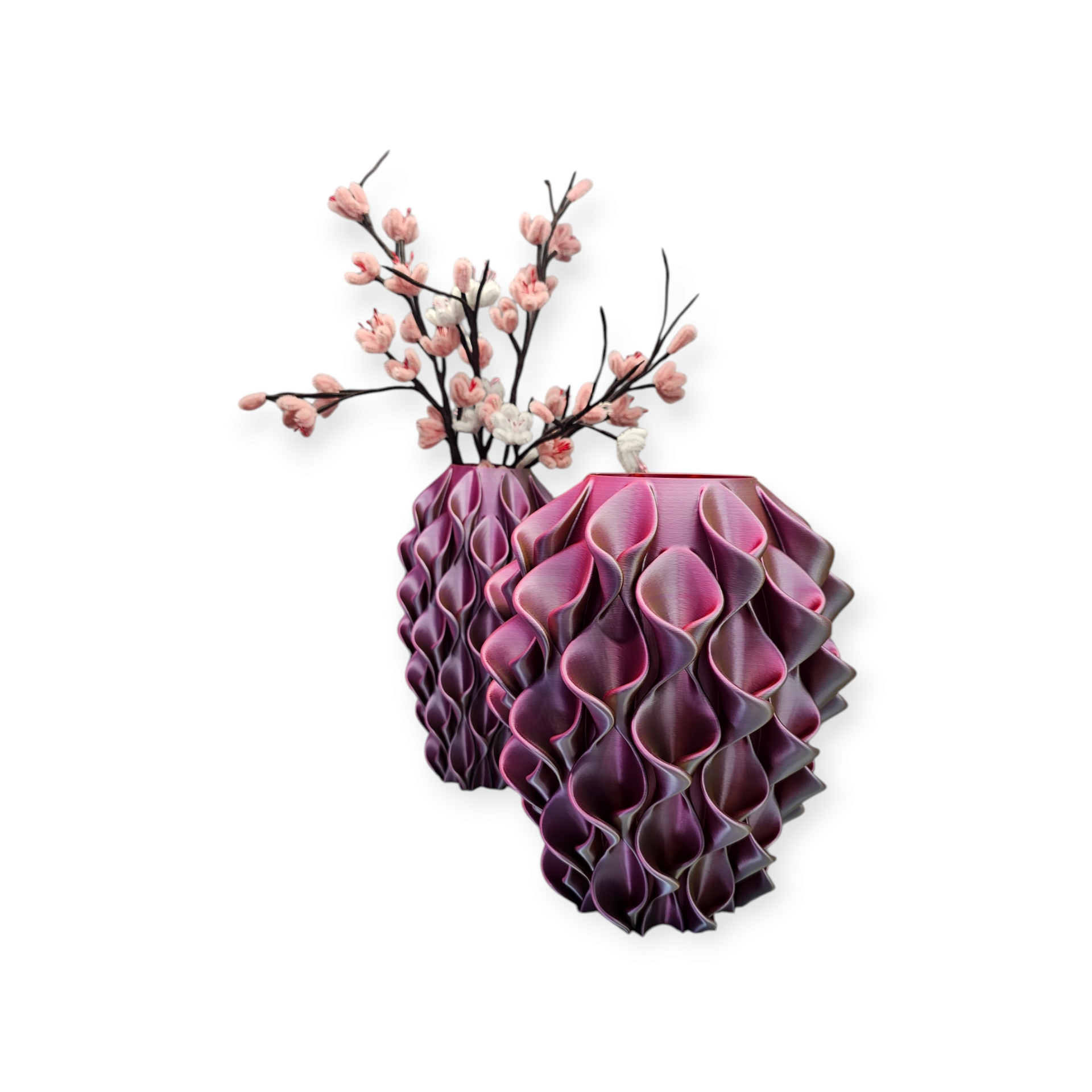 Twee decoratieve, gegolfde, pruimkleurige vazen, waarvan er één een tak met kleine roze bloesems bevat, tegen een witte achtergrond.