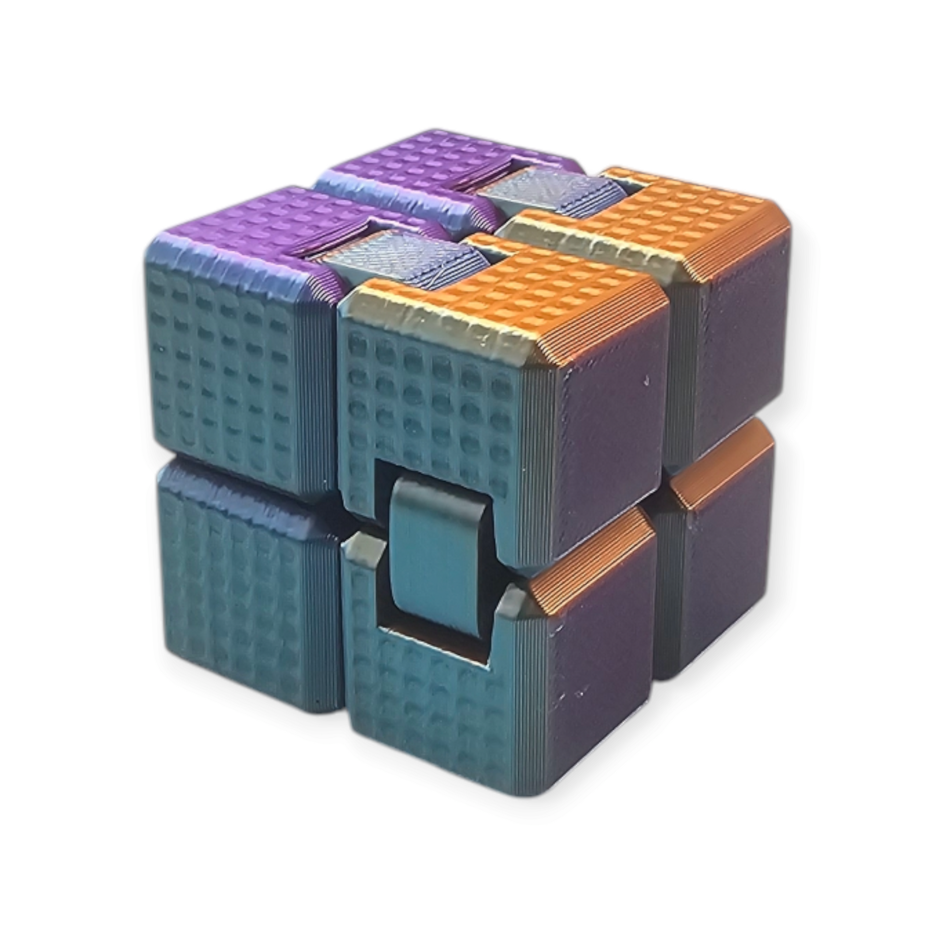 Een metalen oneindigheidskubus-fidgetspeeltje met een gestructureerd oppervlak, gekleurd in een wisselend kleurverloop van paars, goud en turquoise.
