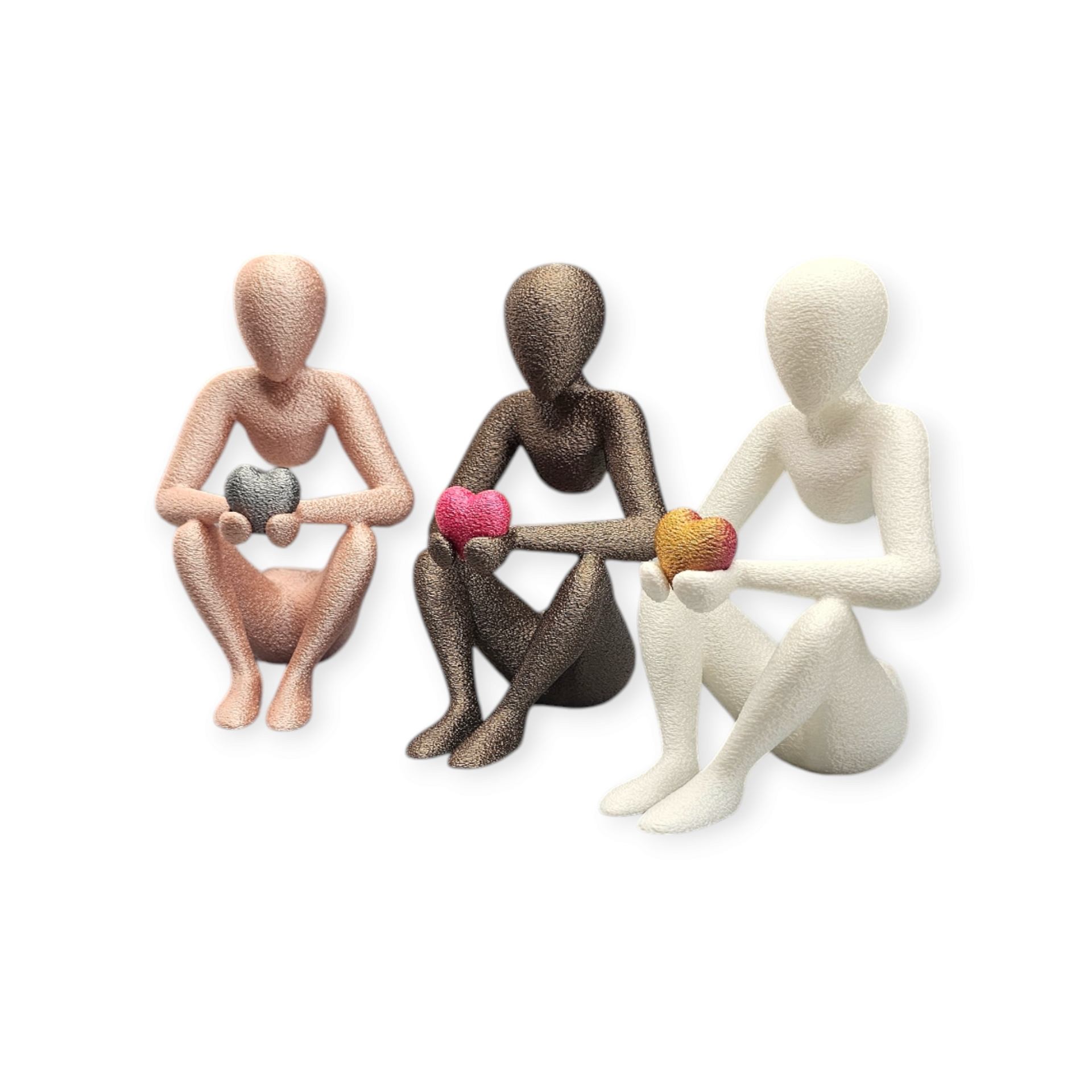 Drie gestileerde figuren in roségoud, brons en wit zitten op een rij, elk met een klein, gestructureerd hartje in de hand.