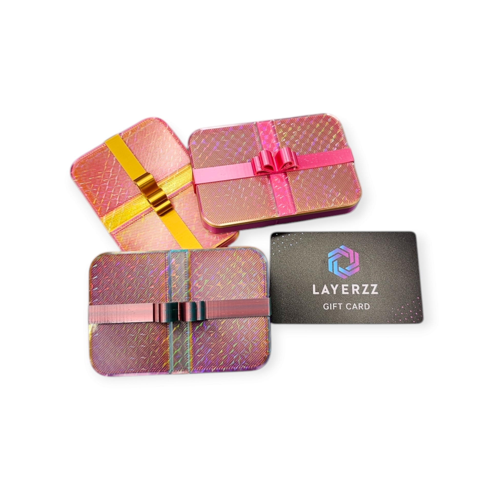 Vier geschenkblikken met decoratieve linten en een zwarte Layerzz-cadeaukaart op een witte achtergrond.