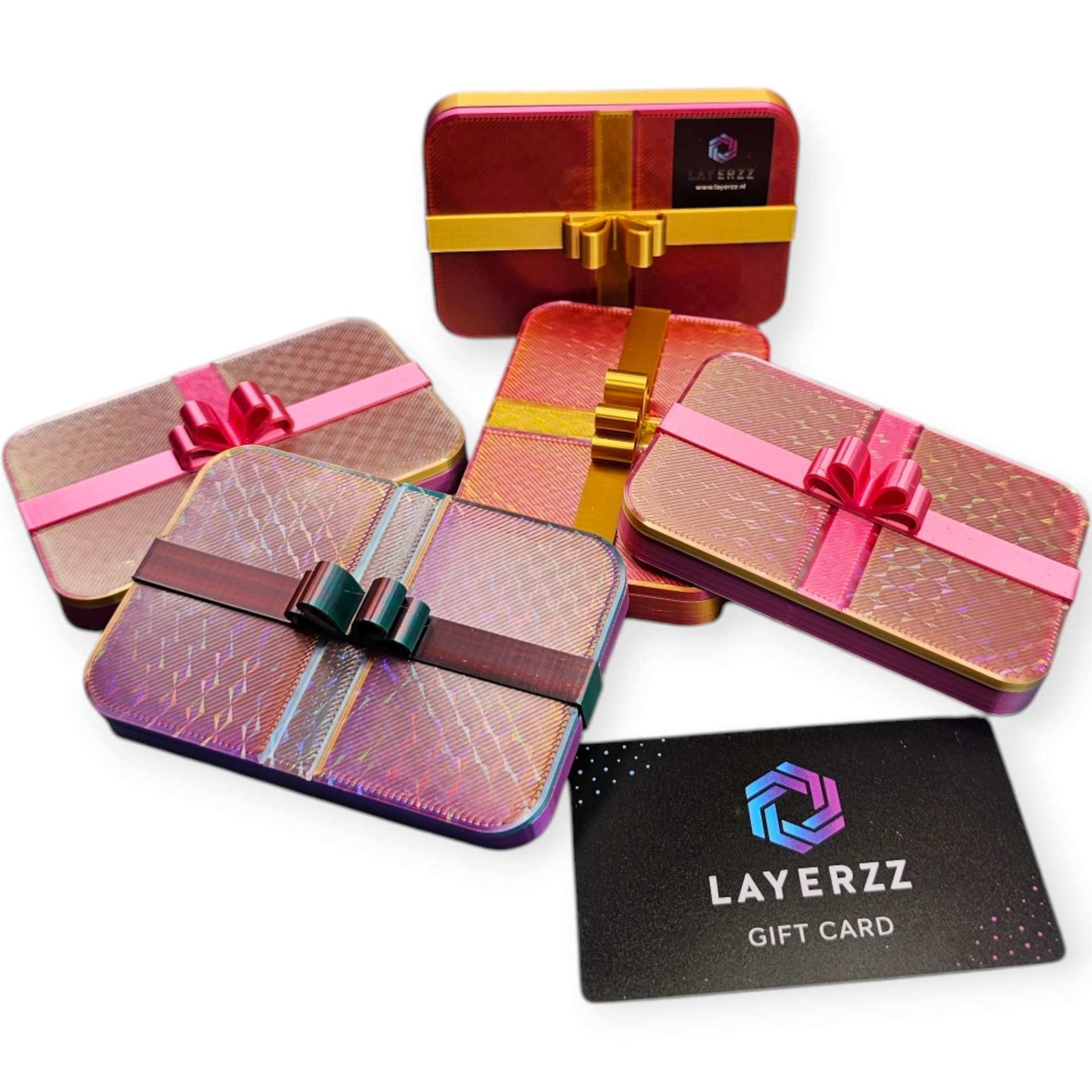 Vier geschenkblikken met decoratieve linten en een zwarte Layerzz-cadeaukaart op een witte achtergrond.
