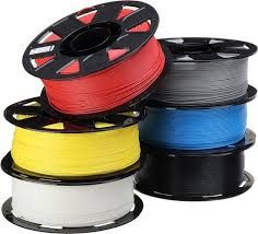 Spoelen met kleurrijk 3D-printfilament: rood, geel, blauw, grijs, zwart en wit.