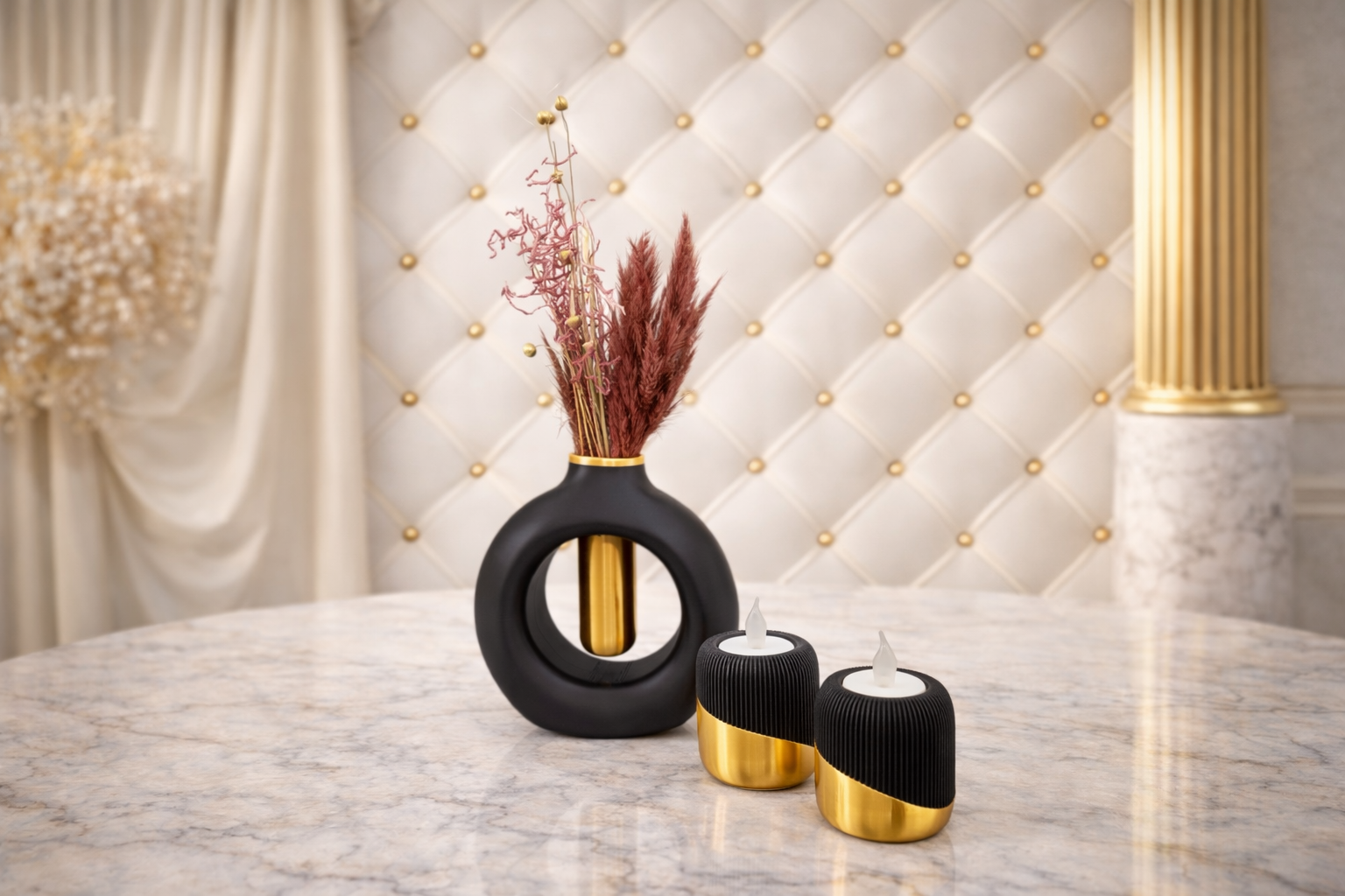 Twee zwart-gouden kandelaars en een bijpassende geometrische vaas met witte bloemen op een zwarte marmeren tafel.