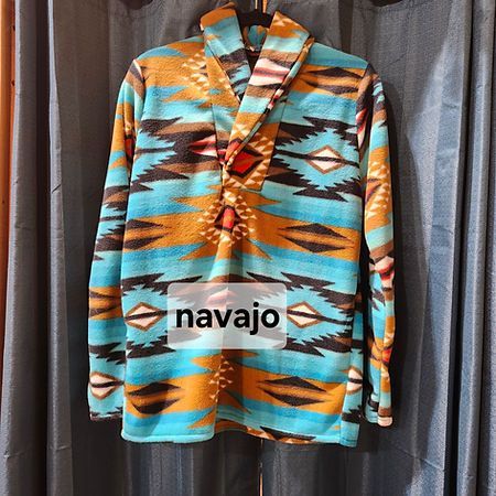A long-sleeved fleece pullover with a turquoise, tan, and black geometric southwestern pattern and a shawl collar.