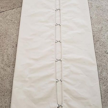A rectangular, off-white fabric panel featuring a vertical silver-toned metal chain connector down the center.