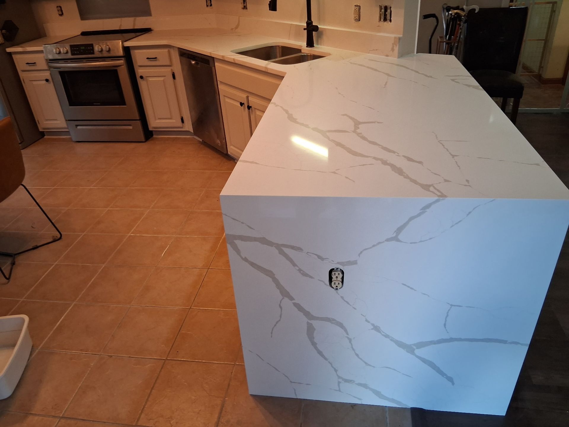 Modern kitchen with a large white marble-pattern island in the foreground
