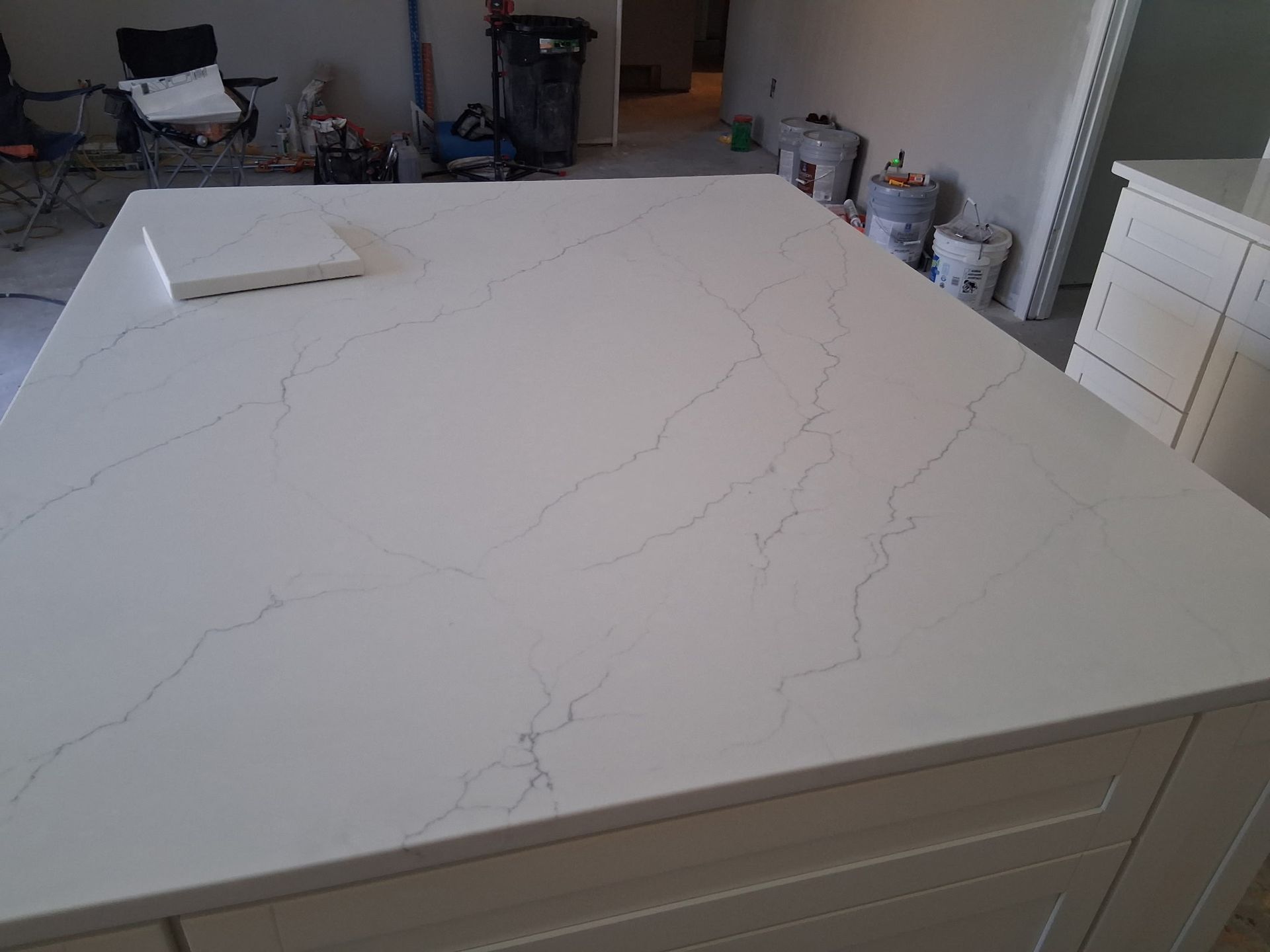White quartz kitchen island countertop with gray veining in a kitchen under renovation