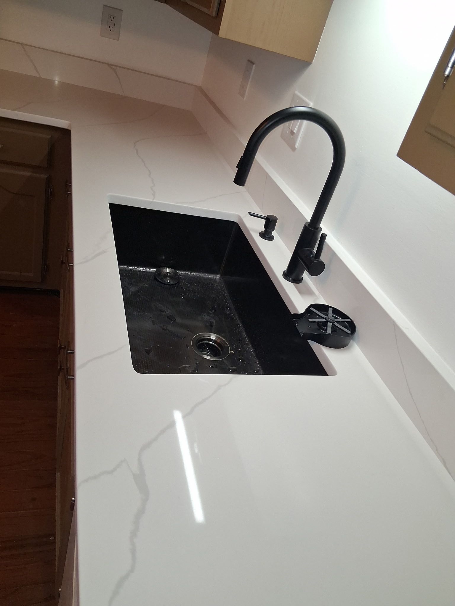 Modern white kitchen sink with black faucet and countertop sink basin