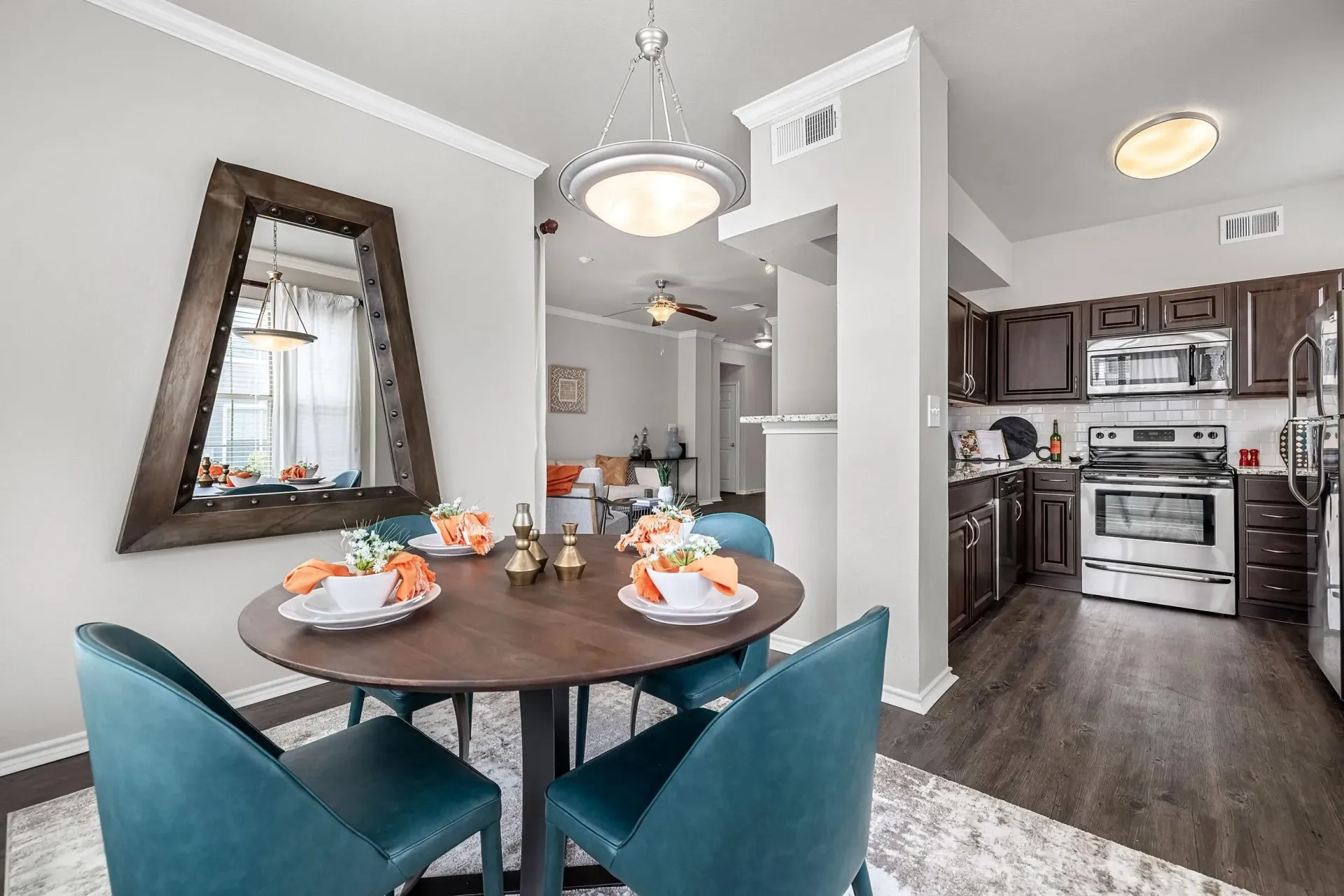Dining area and kitchen with dark wood cabinets and stainless steel appliances.