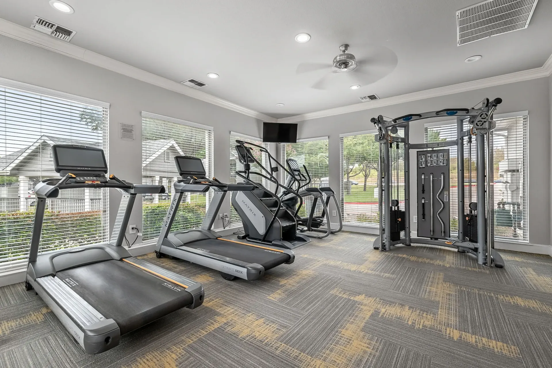 Fitness center with treadmills, stair climber, elliptical, and weight machine.
