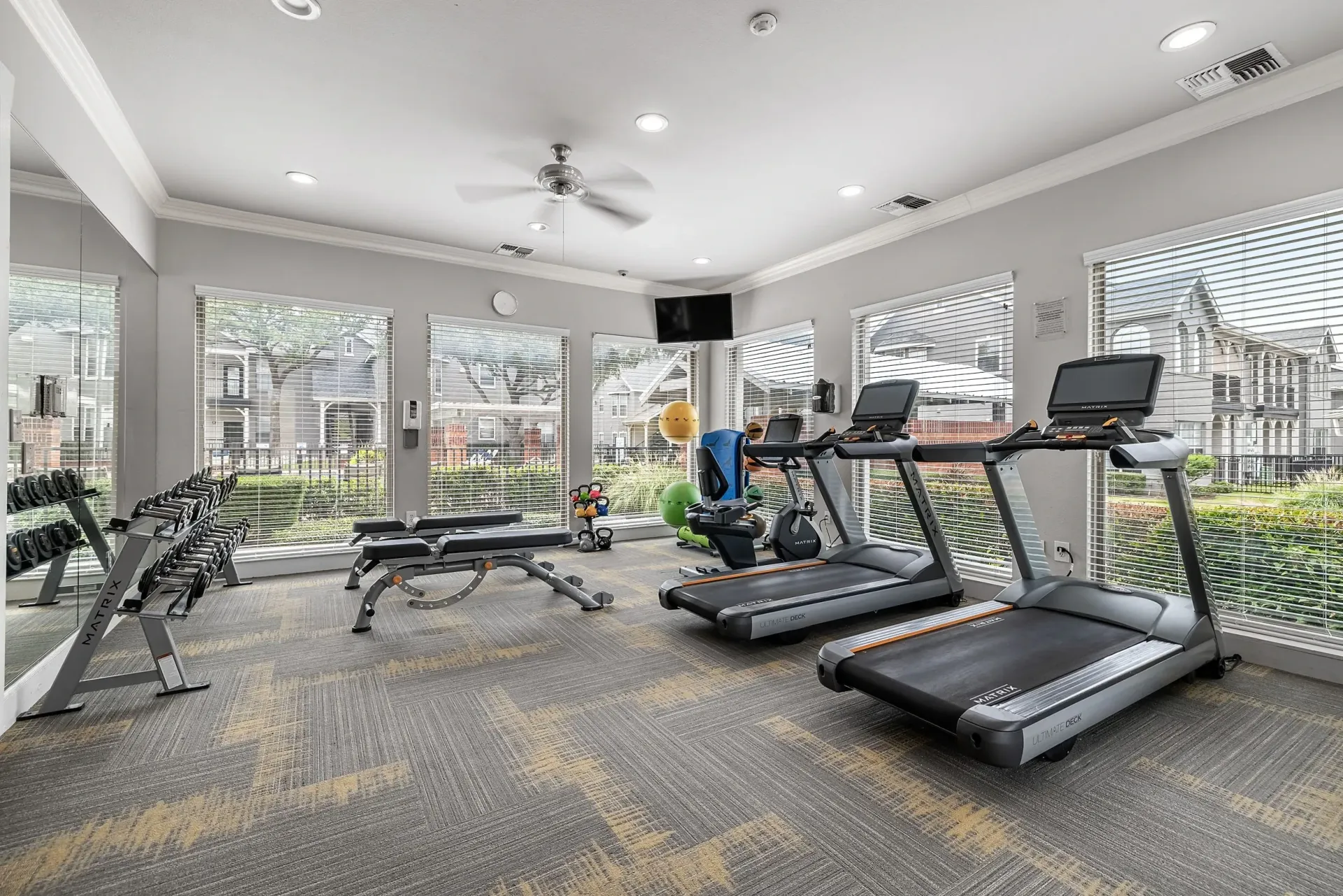 Gym with treadmills, weights, and exercise equipment.