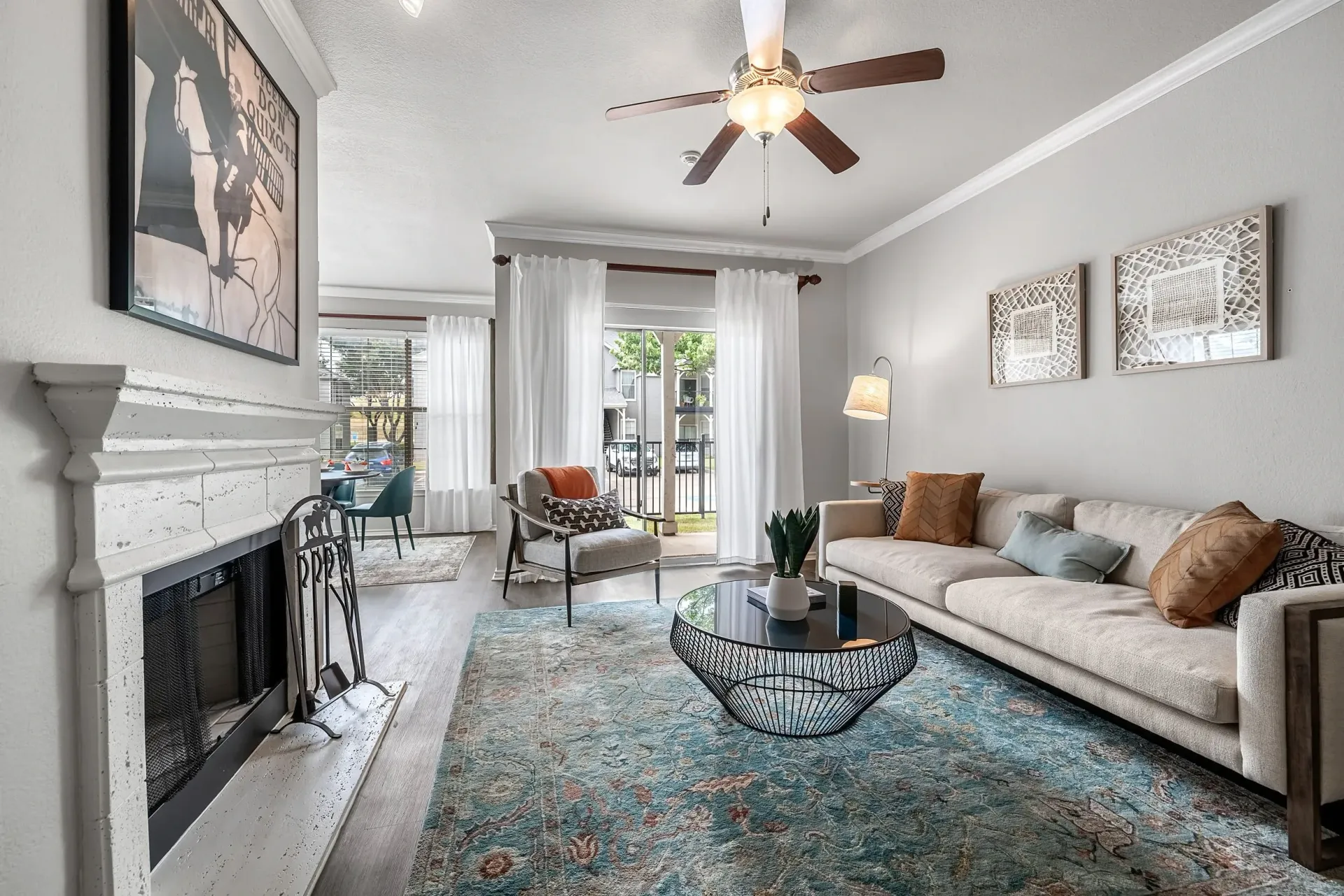 Living room with a sofa, coffee table, fireplace, and dining area visible.