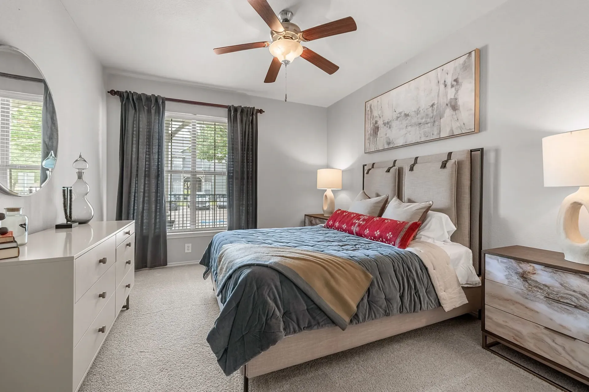 Main bedroom with a king-size bed, ceiling fan, and large dresser.
