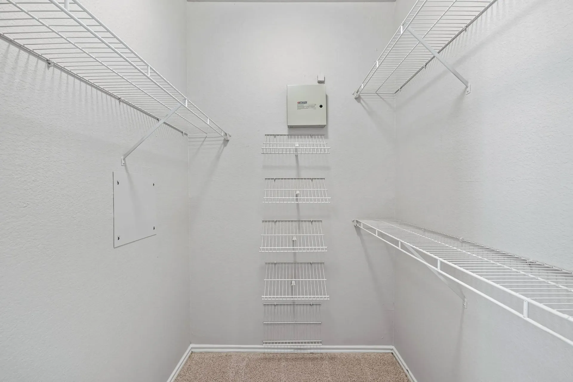 Empty walk-in closet with white wire shelving.