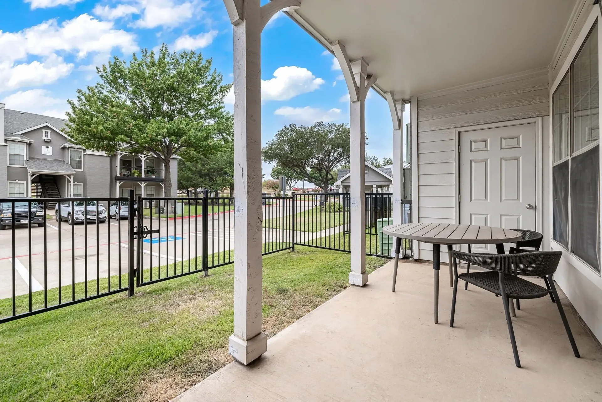 Private patio with table and chairs overlooking the property grounds and buildings.