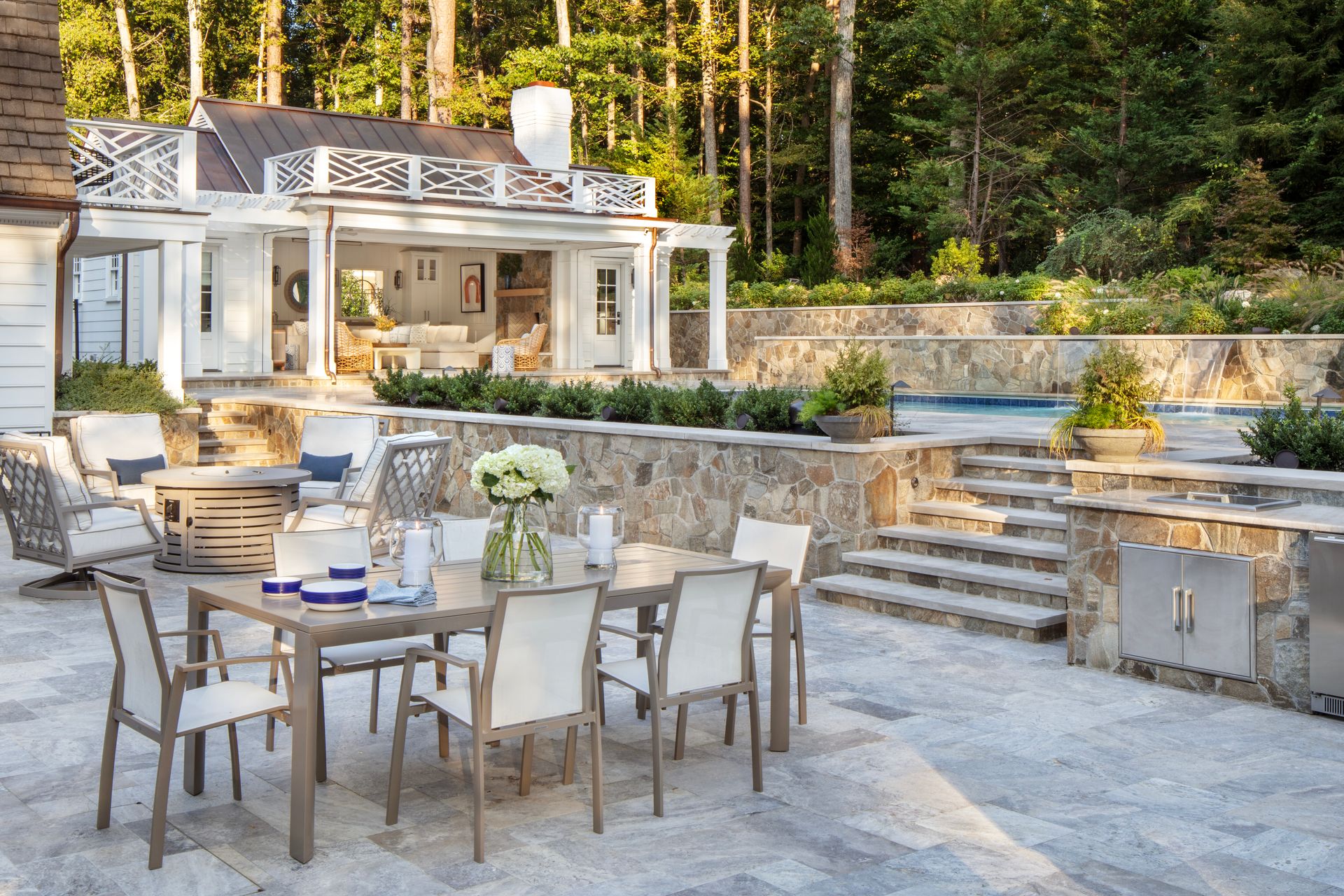 Outdoor dining area with table and chairs, poolside patio, and a white gazebo-style structure.