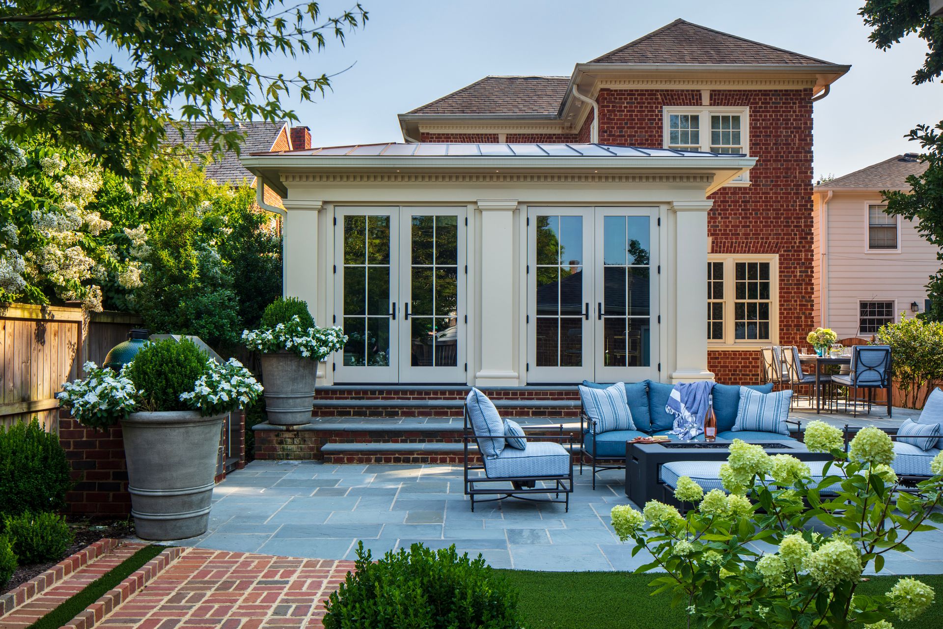 A large brick house with a patio area in front of it.