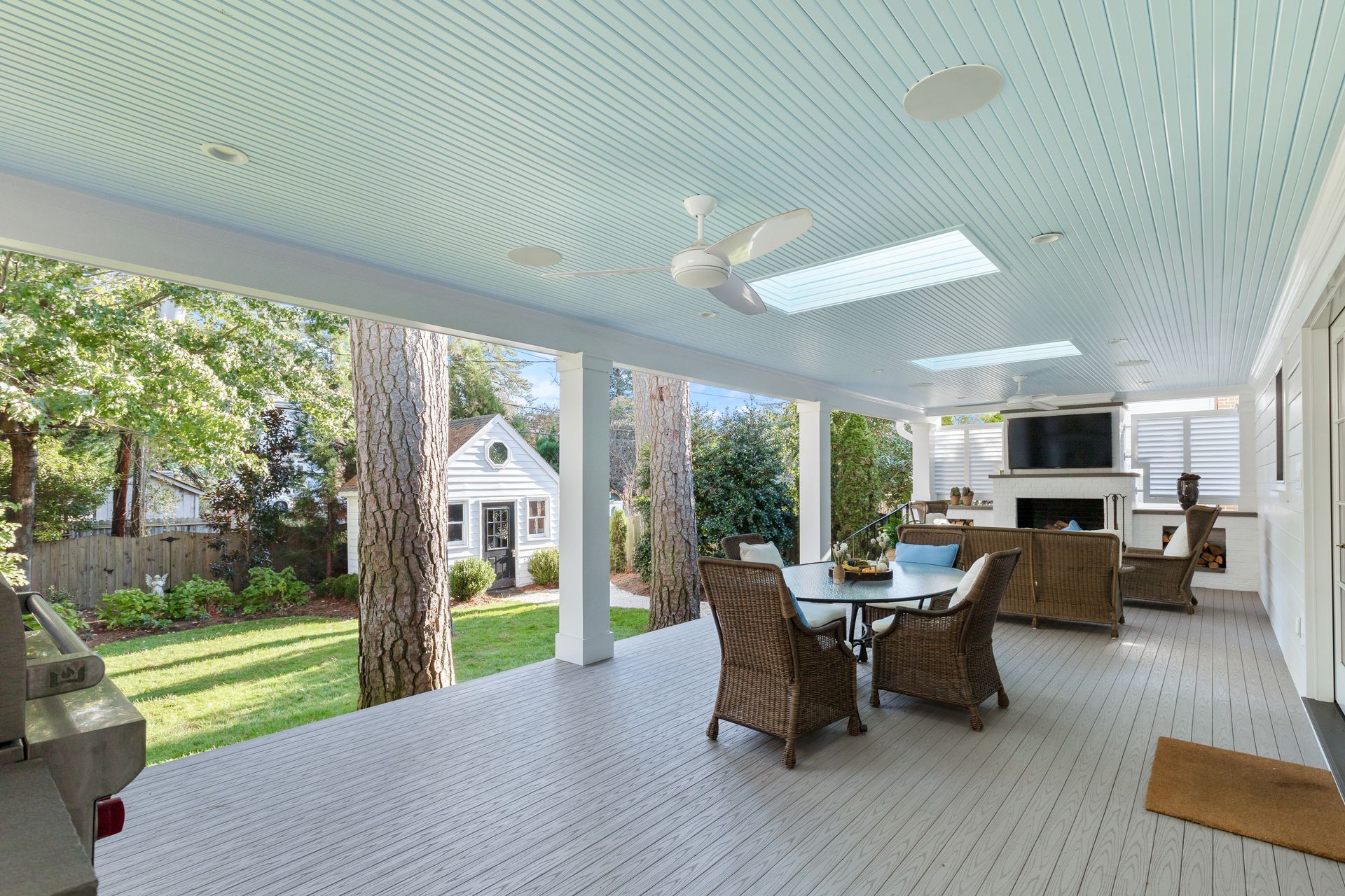 a patio with a table and chairs and a ceiling fan