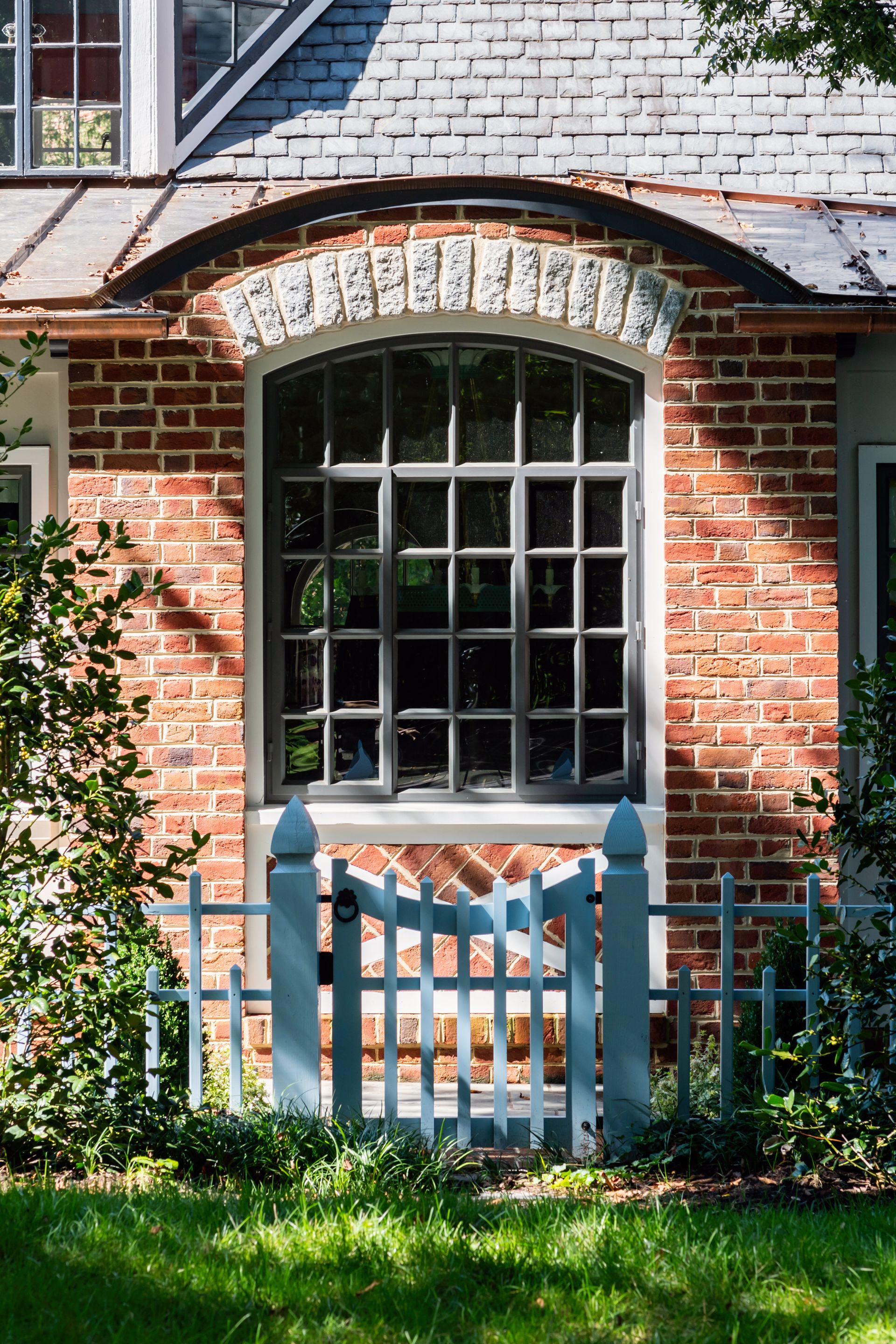 a brick house with a blue gate in front of it