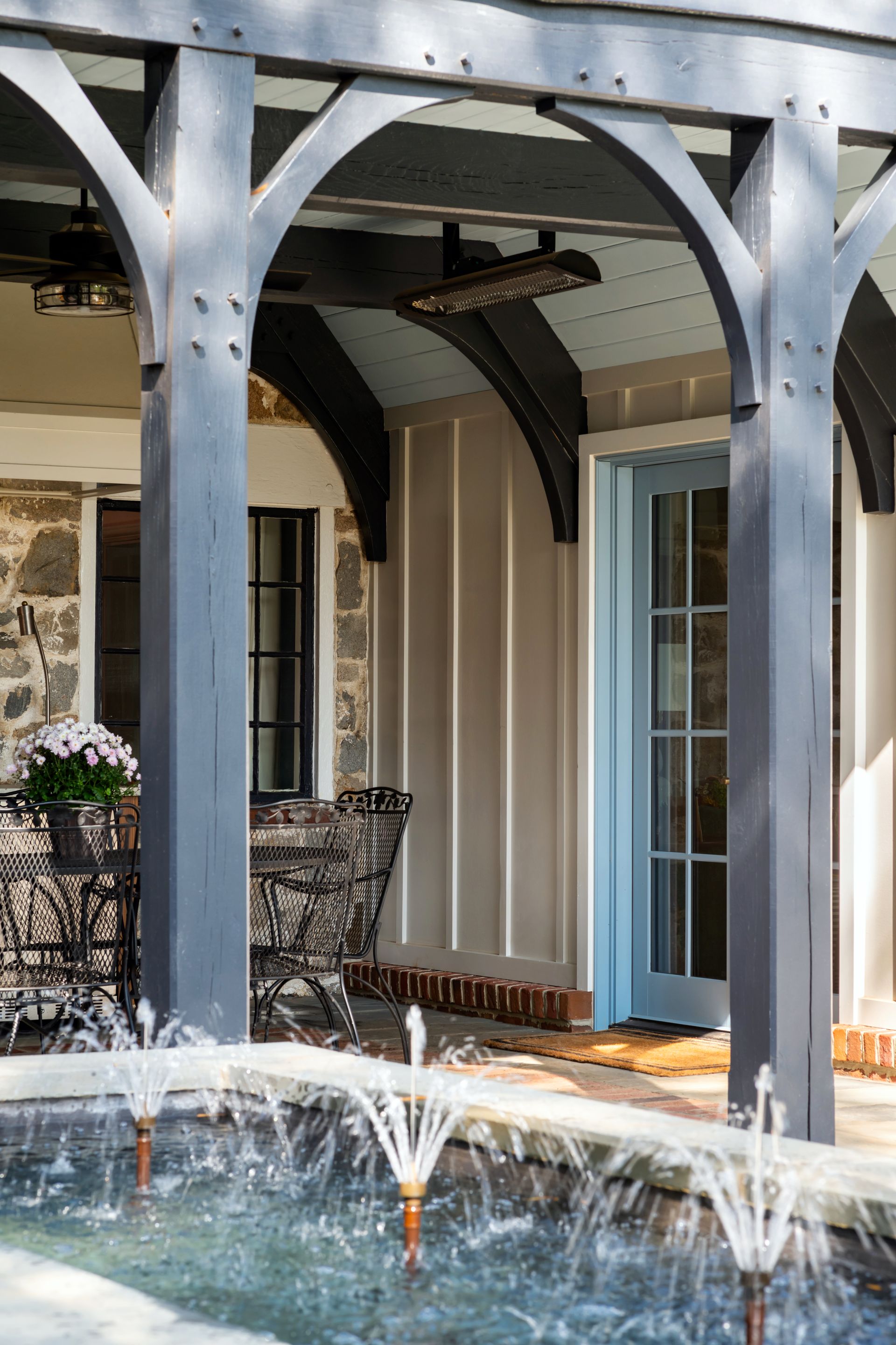 a patio with a table and chairs and a fountain