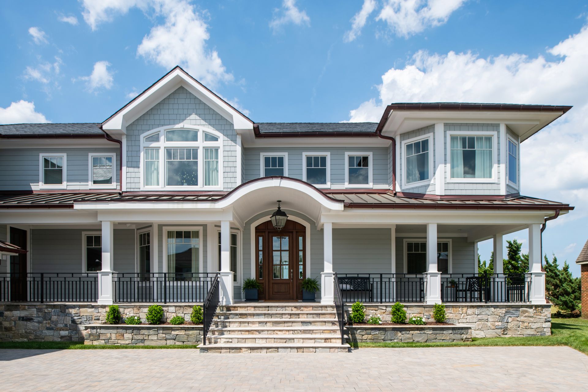 a large house with a large porch and stairs