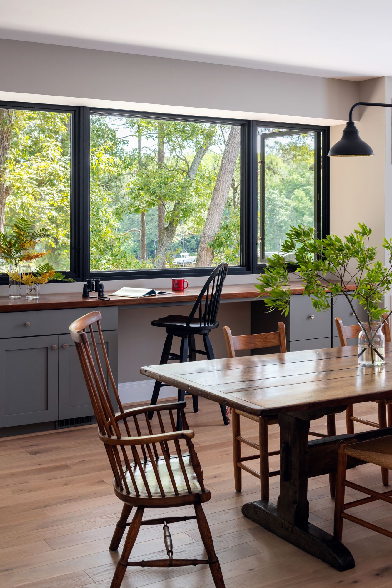 A dining room with a table and chairs and a large window.