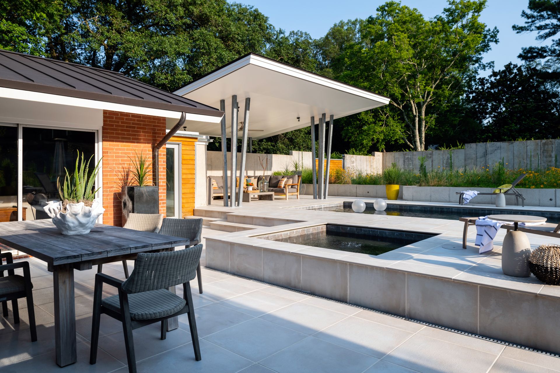 a patio with a table and chairs and a pool