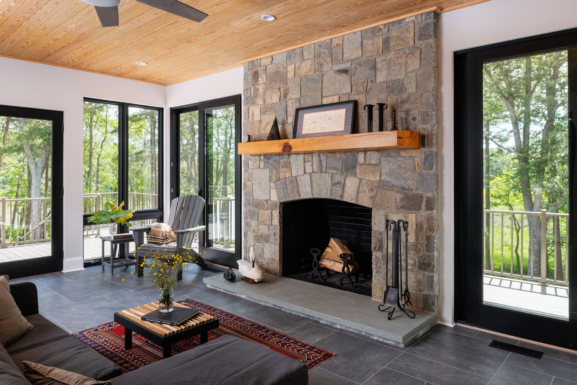 A living room with a fireplace and a lot of windows.