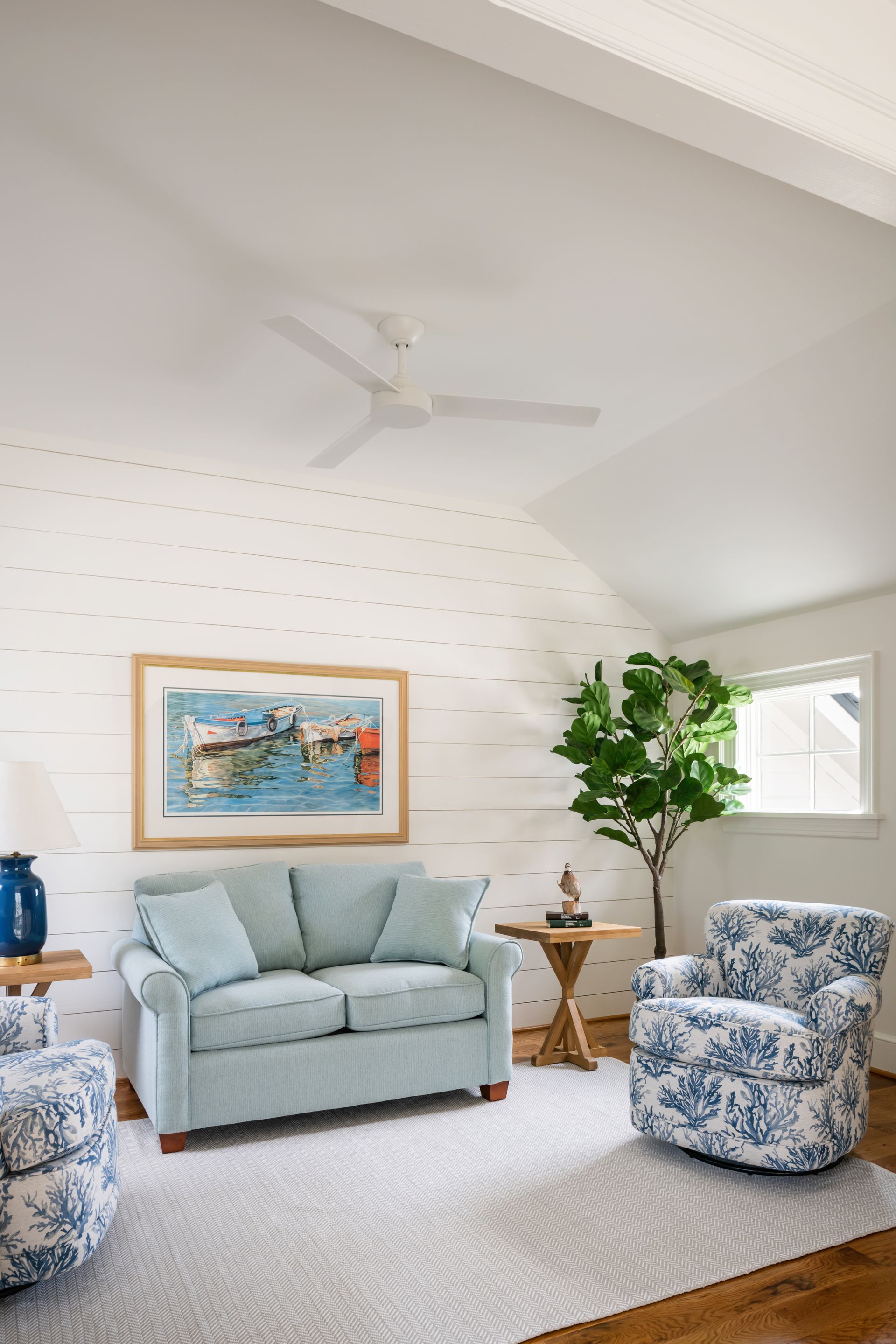 a living room with a blue couch and two chairs